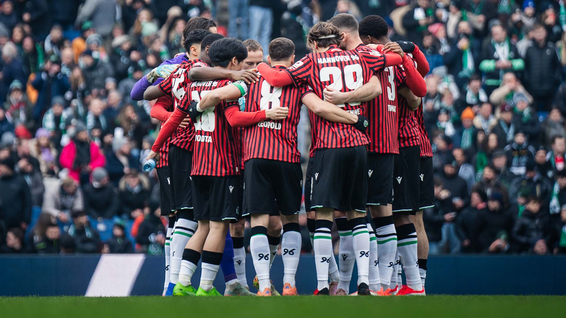 Die 96-Mannschaft bildet einen Kreis im Stadion.
