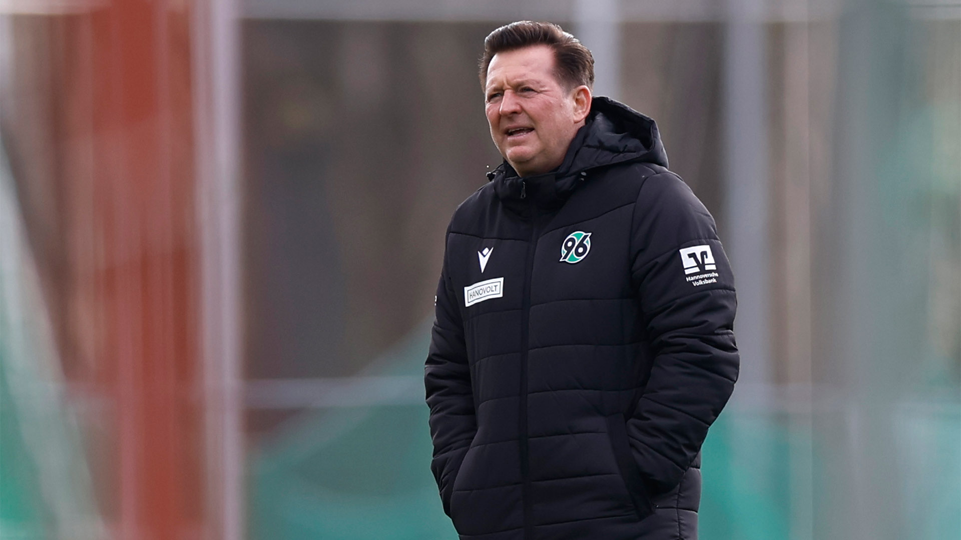 Christian Titz in dicker Jacke mit Händen in den Taschen beim Training.