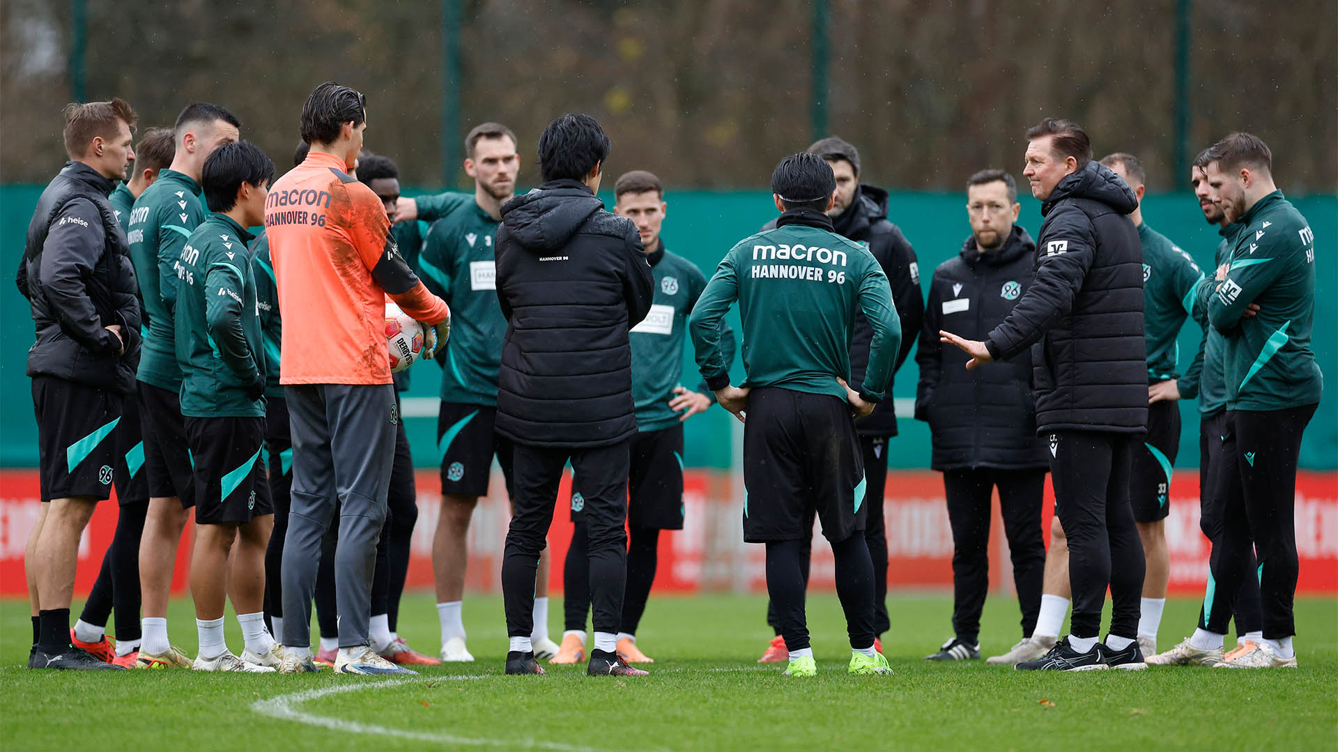 Christian Titz steht mit seiner Mannschaft im Kreis auf dem Trainingsplatz.