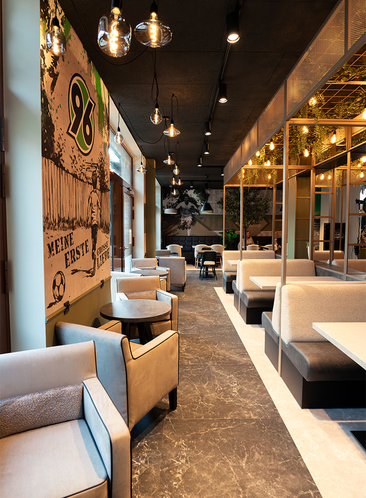 Blick in das leere 96-Café mit einem großen 96-Logo an der Wand.