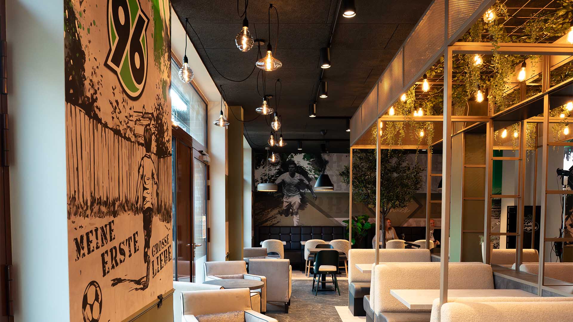 Blick in das leere 96-Café mit einem großen 96-Logo an der Wand.