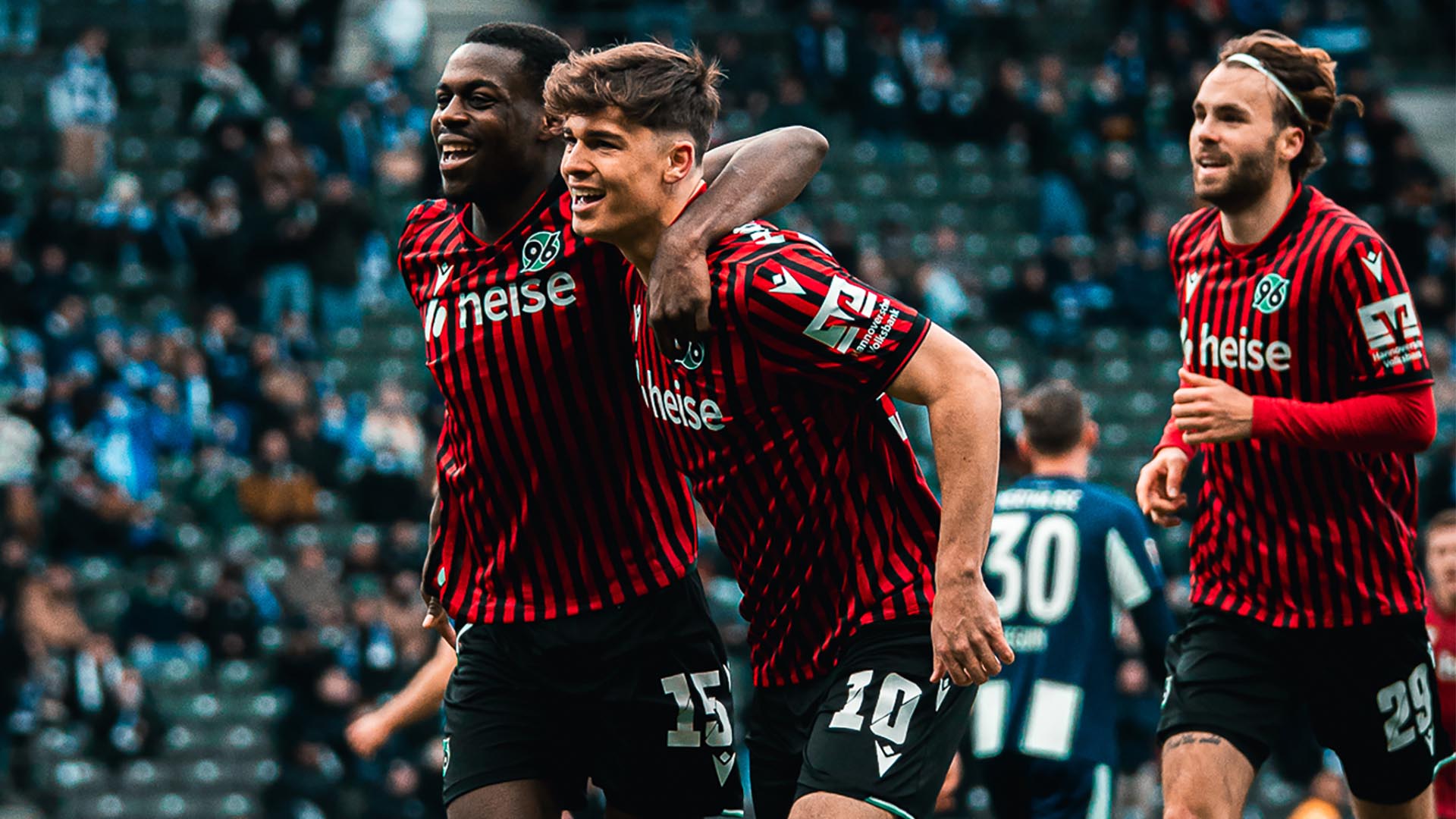 Noel Aseko und Noah Weißhaupt jubeln, im Hintergrund läuft Kolja Oudenne. 