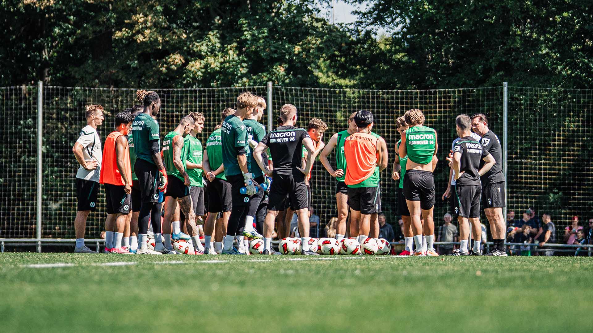 Die Mannschaft steht in einem Kreis auf dem Trainingsplatz.