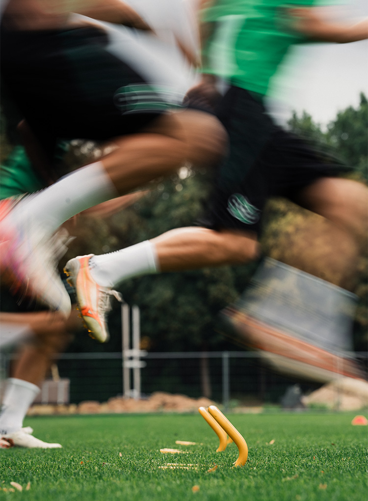 Unscharfe Aufnahme von Spielerbeinen in Bewegung.