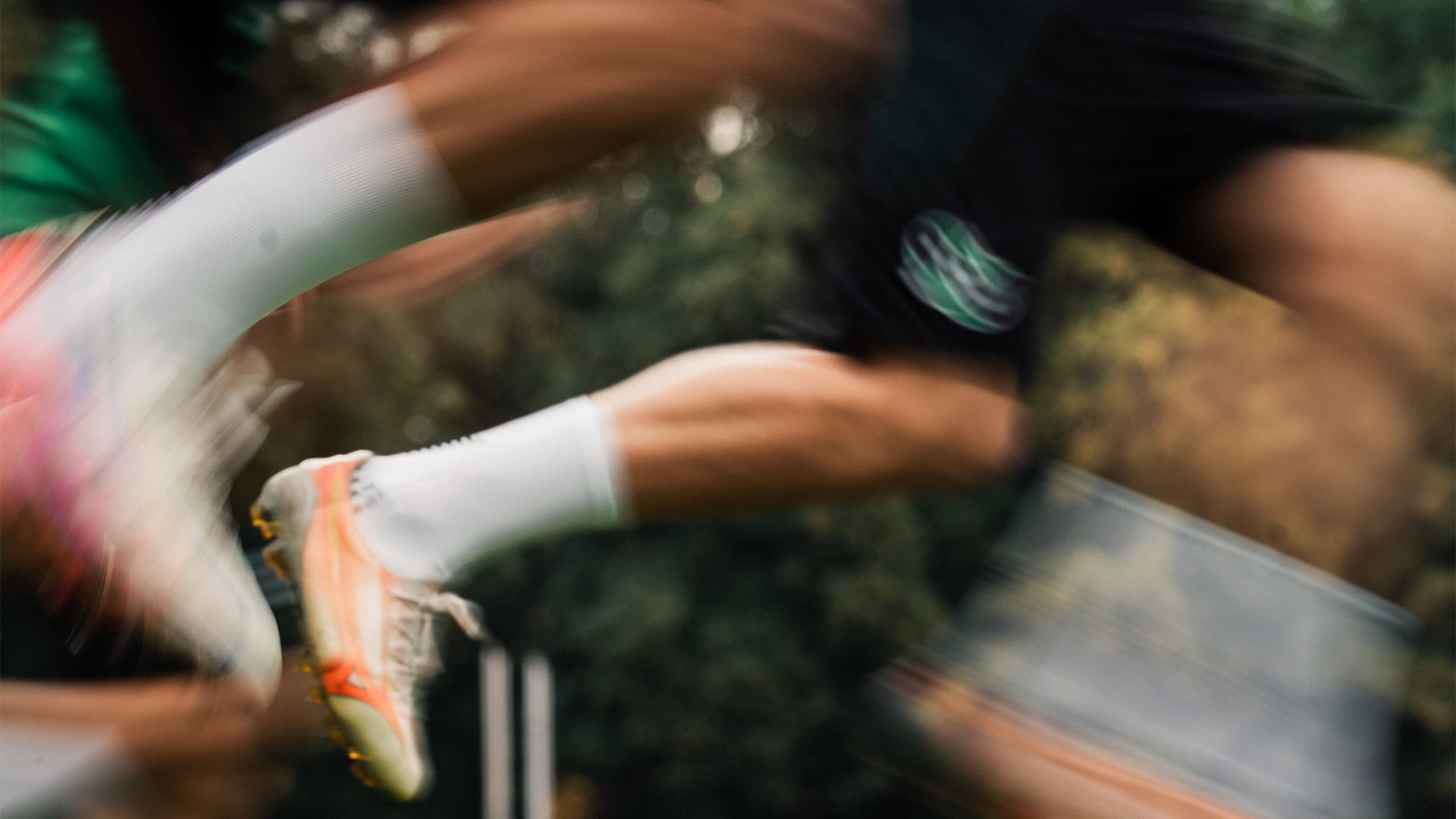 Unscharfe Aufnahme von Spielerbeinen in Bewegung.