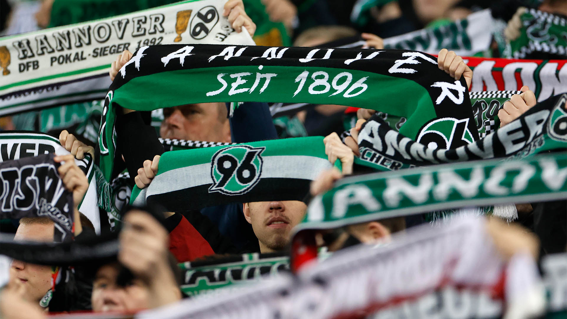 96-Schals werden in die Höhe gehalten.