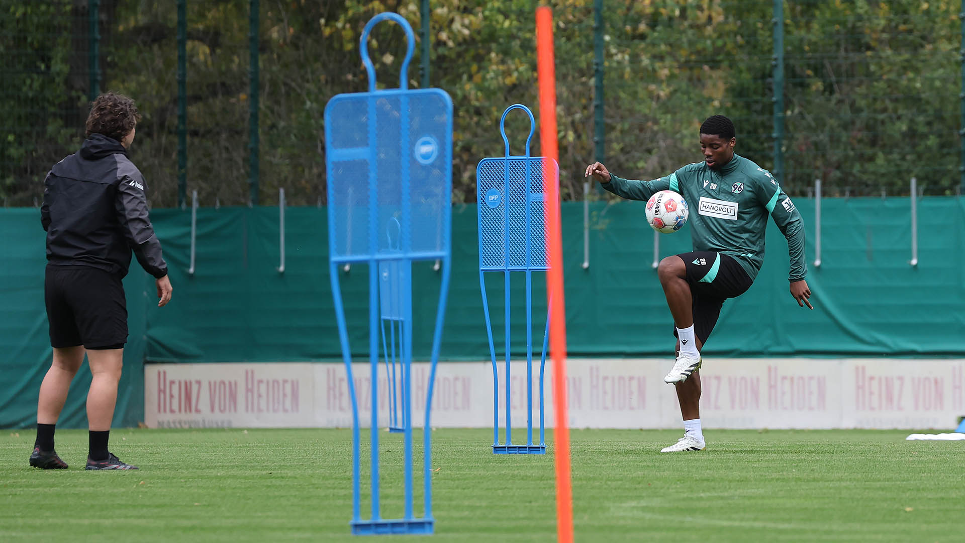 Ime Okon hält auf dem Trainingsplatz den Ball hoch.