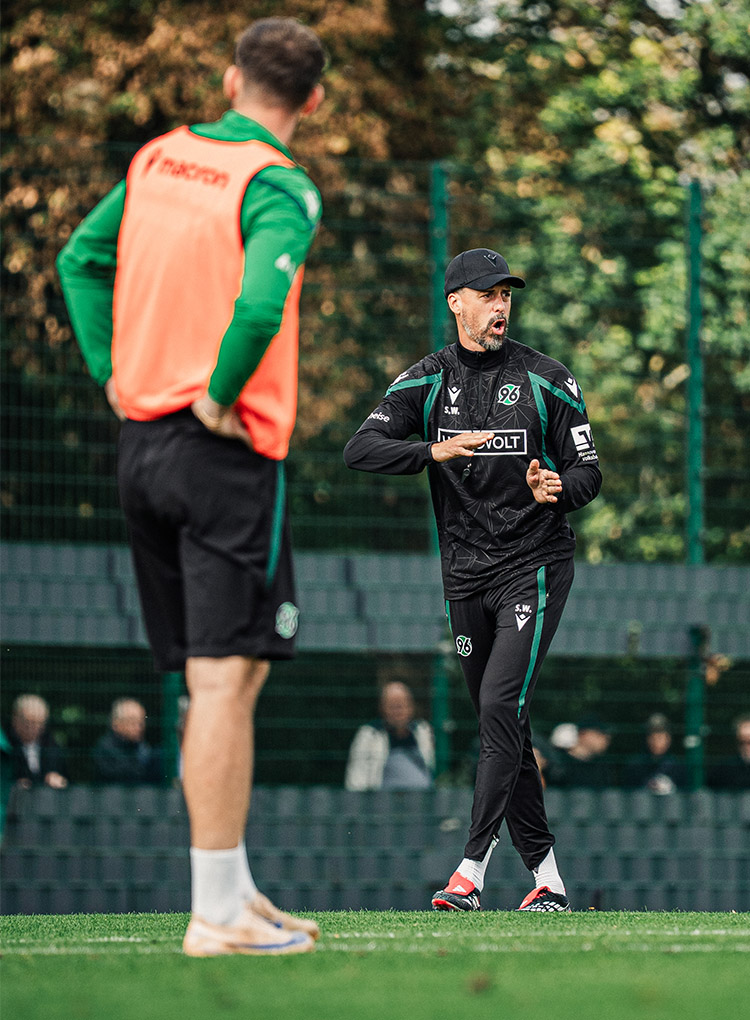 Der 96-Trainer Sandro Wagner steht auf dem Trainingsplatz, sagt etwas an und gestikuliert dabei mit den Händen.