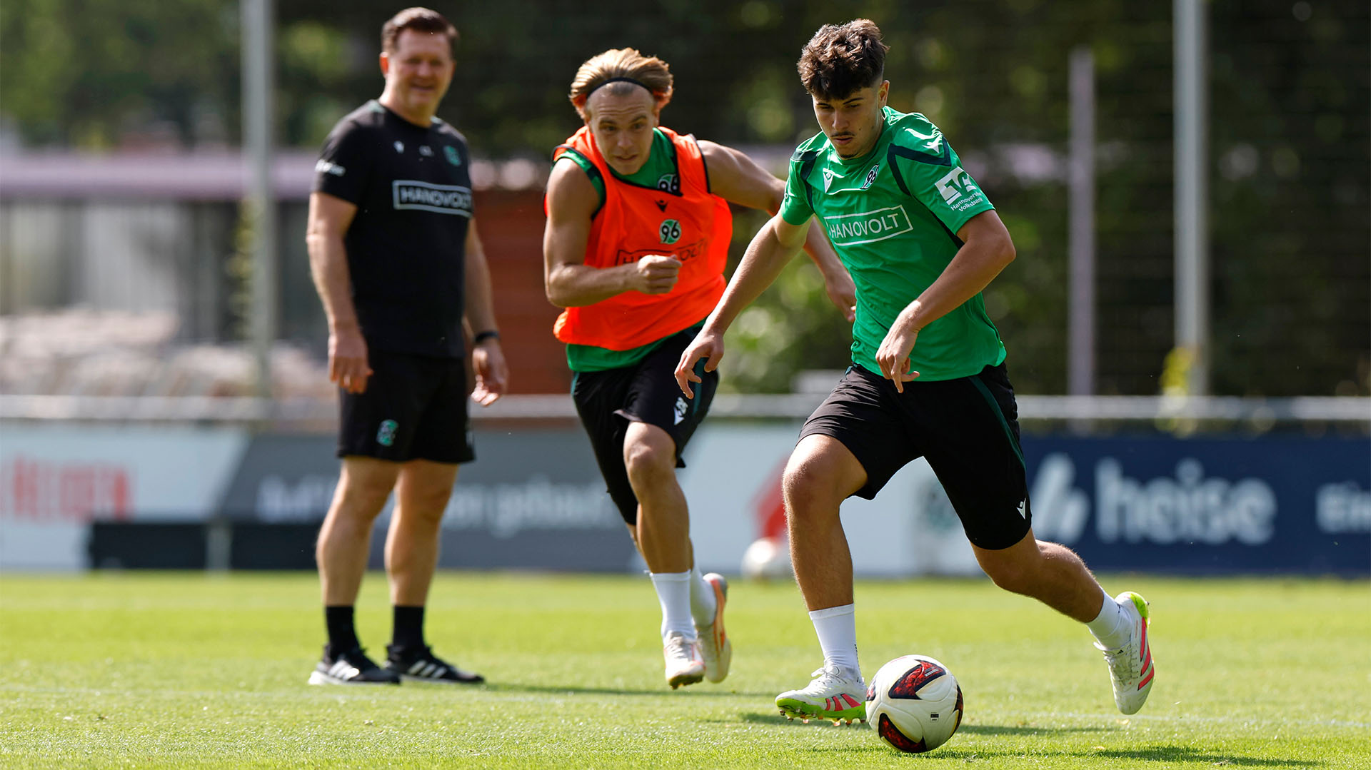 Der neue 96-Spieler Karl Steinmann ist im Training am Ball, im Hintergrund unscharf der 96-Spieler Lars Gindorf und der 96-Trainer Christian Titz.
