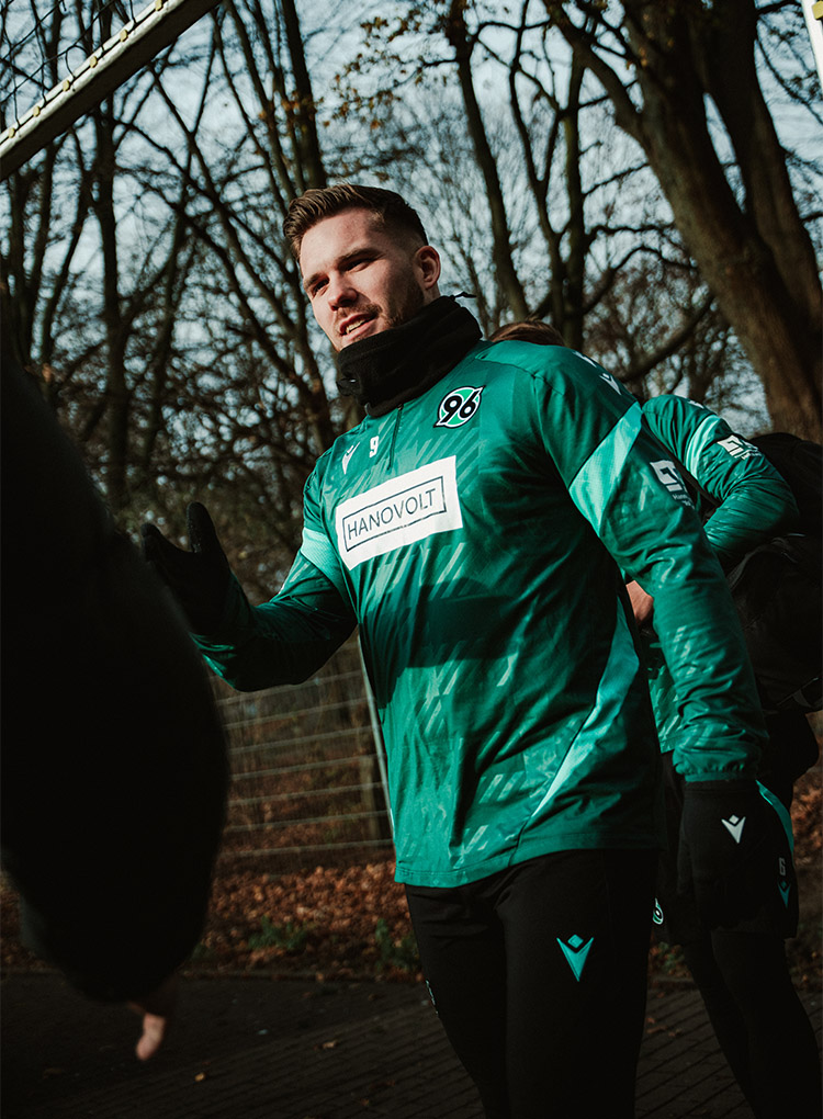 Benjamin Källman betritt den Trainingsplatz und schlägt mit jemandem, der nicht im Bild ist, ein.