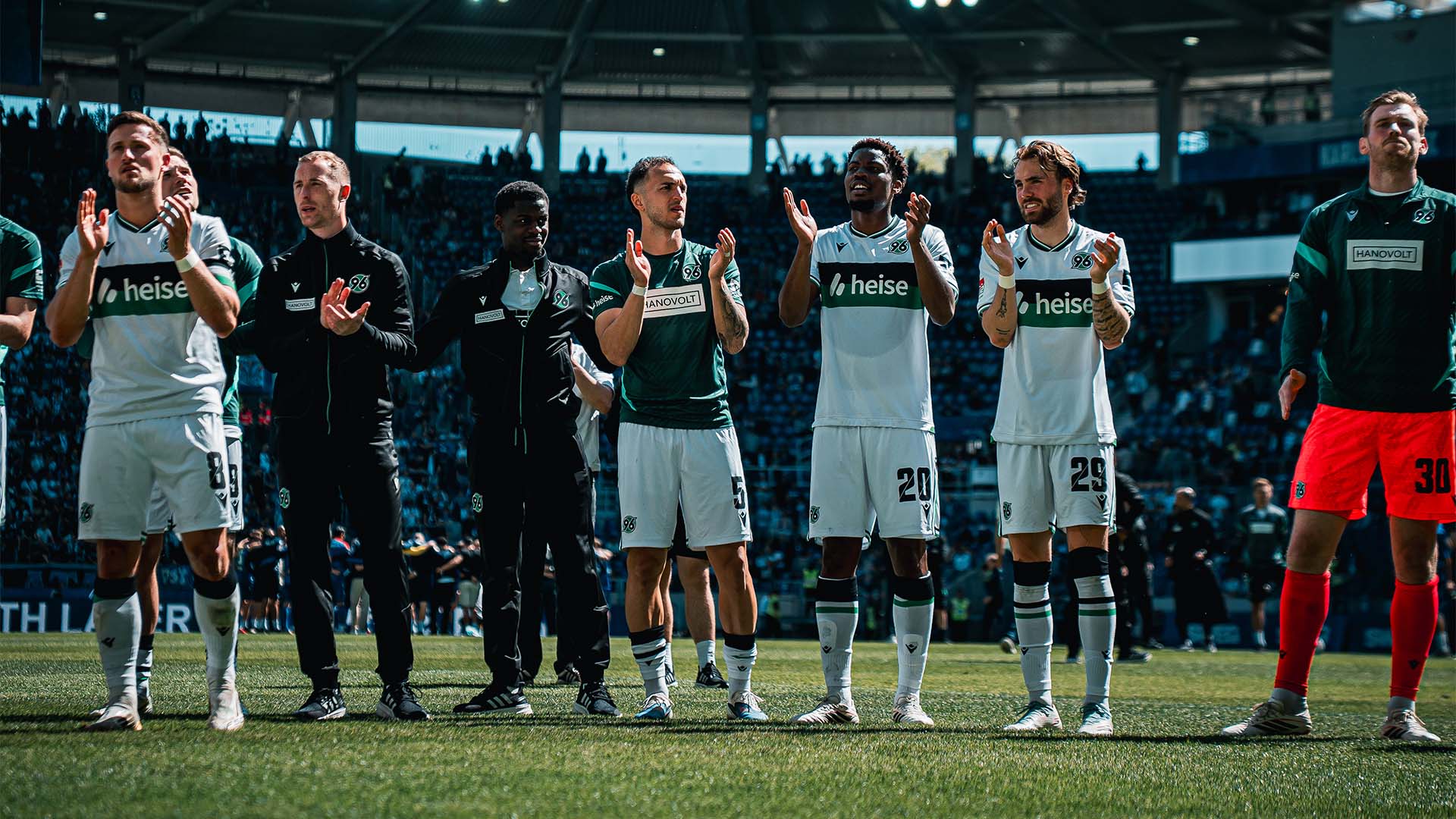 Einige 96-Profis stehen in einer Reihe und applaudieren in Richtung der 96-Fans.