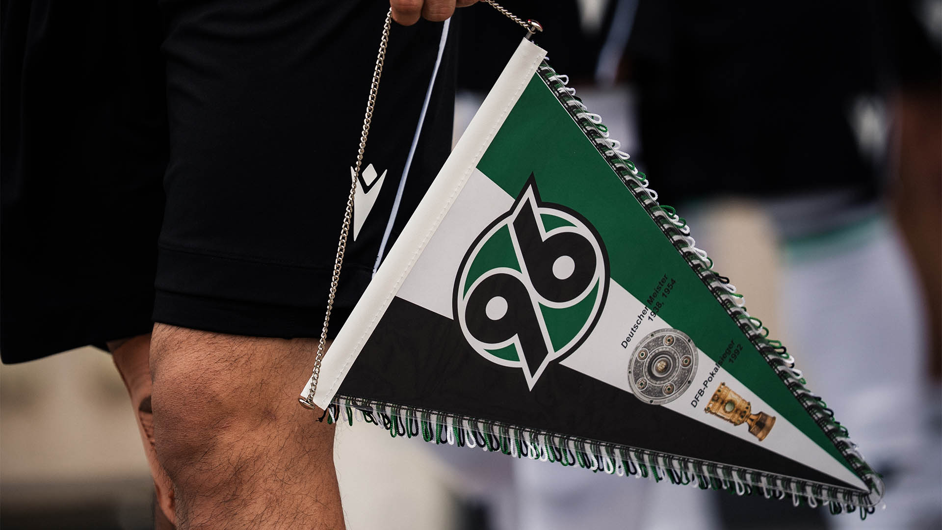 Ein nicht erkennbarer Spieler hält einen 96-Wimpel in der Hand.