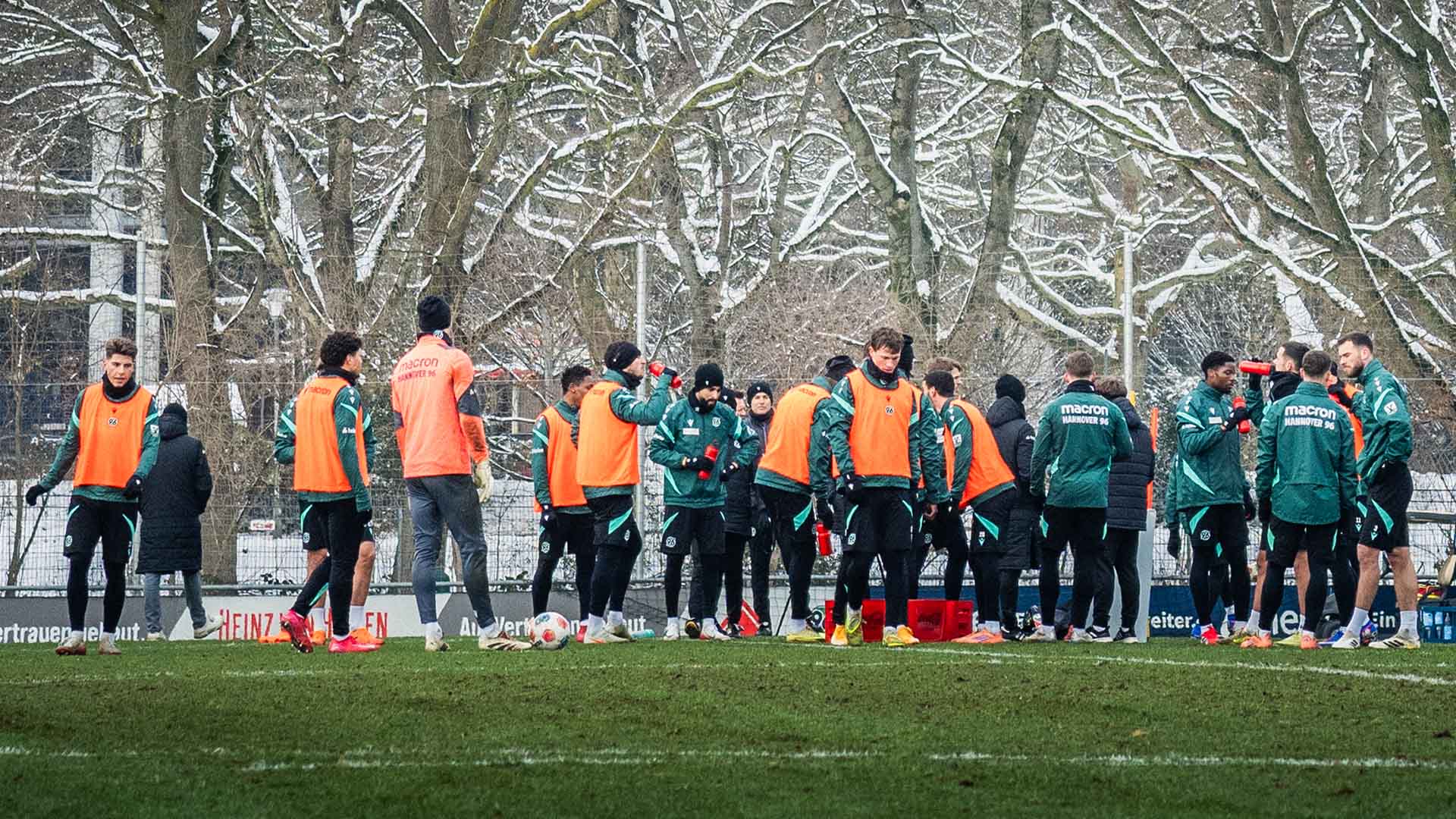 Die 96-Mannschaft steht im Kreis auf dem Trainingsplatz. Im Hintergrund sind schneebedeckte Bäume.