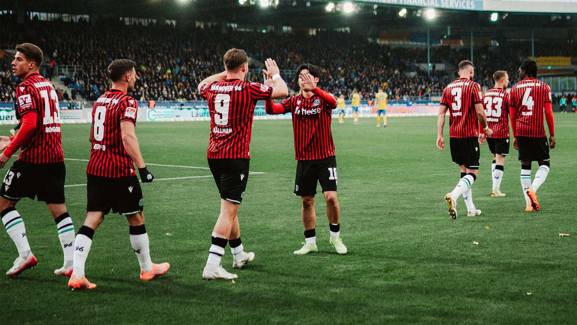 Benjamin Källman und Daisuke Yokota klatschen ab, rundherum sind weitere Spieler. 