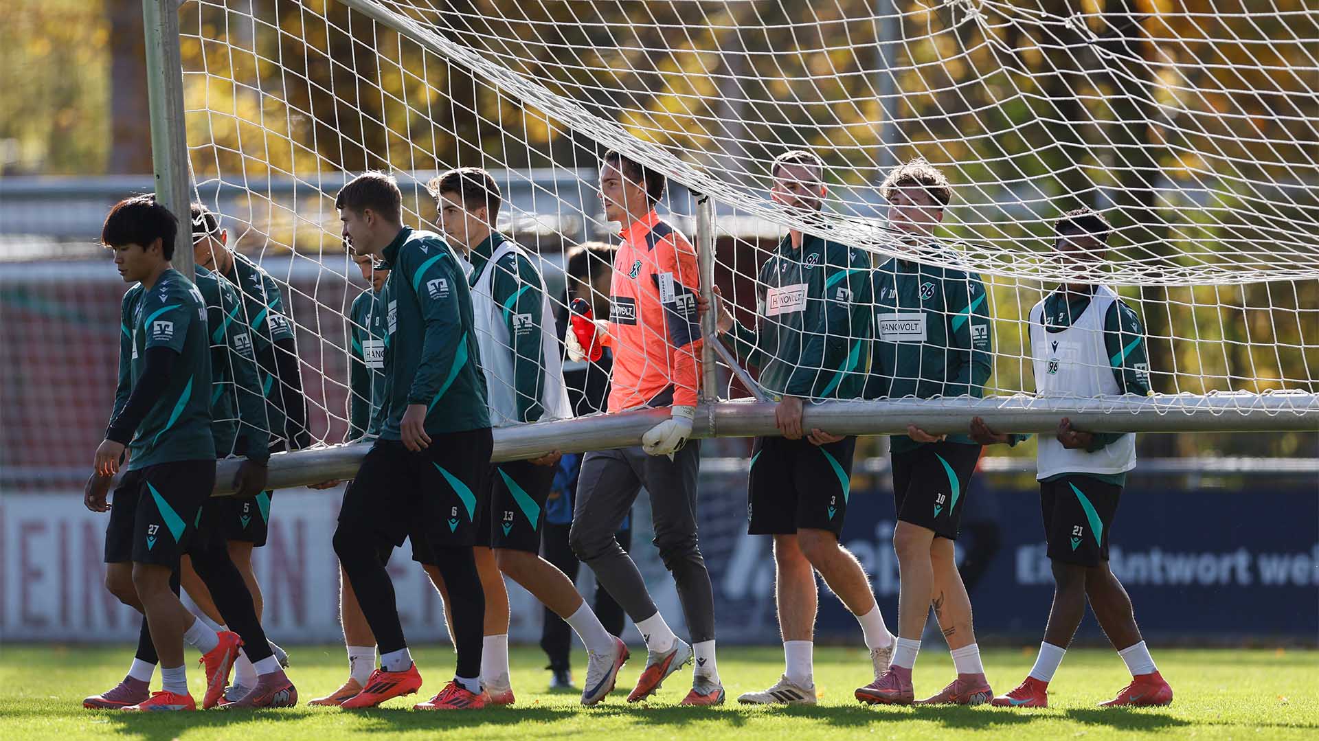Einige Spieler tragen ein Tor.