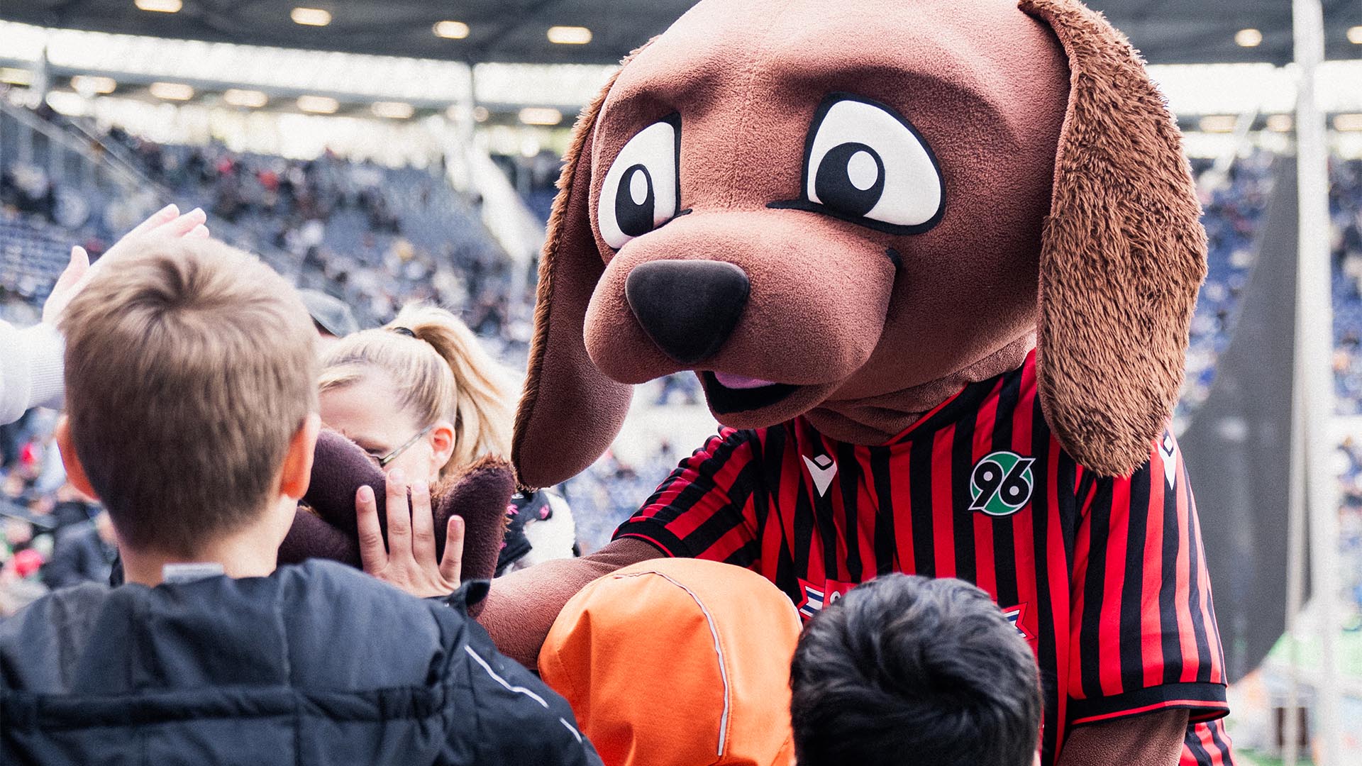 KIDS-Maskottchen EDDI klatscht mit Kindern ab.