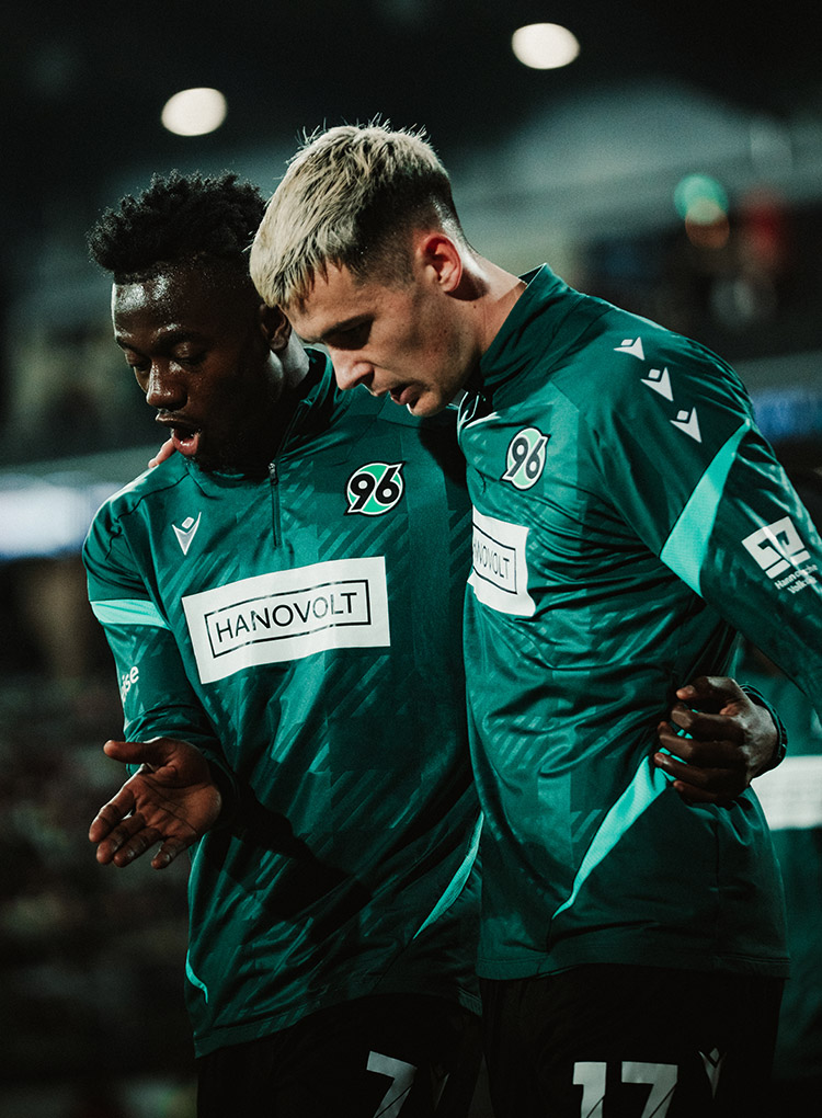Mustapha Bundu und Bastian Allgeier laufen nach einem Spiel Arm in Arm.
