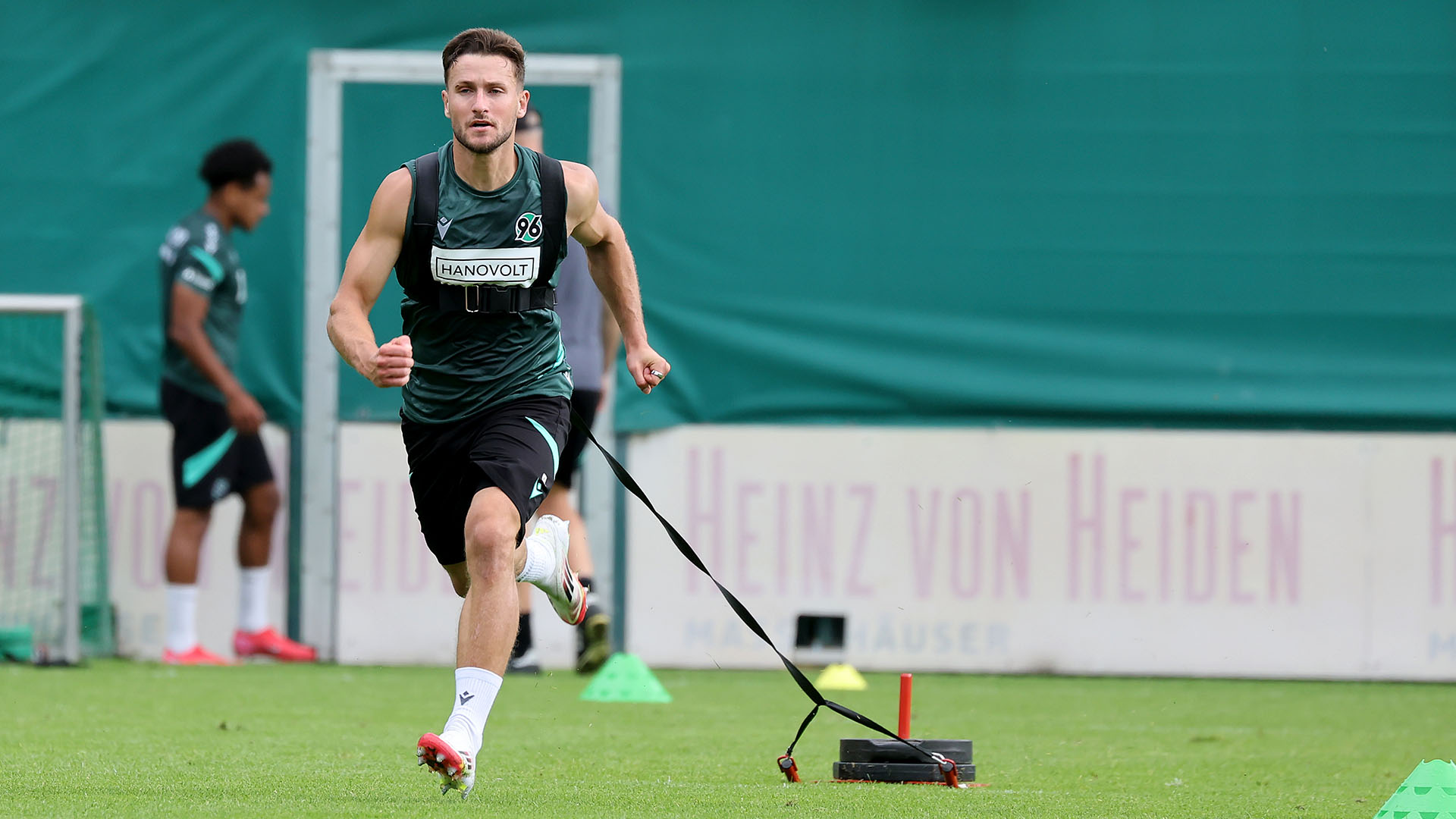 Enzo Leopold zieht einen Trainingsschlitten, läuft dabei auf die Kamera zu.