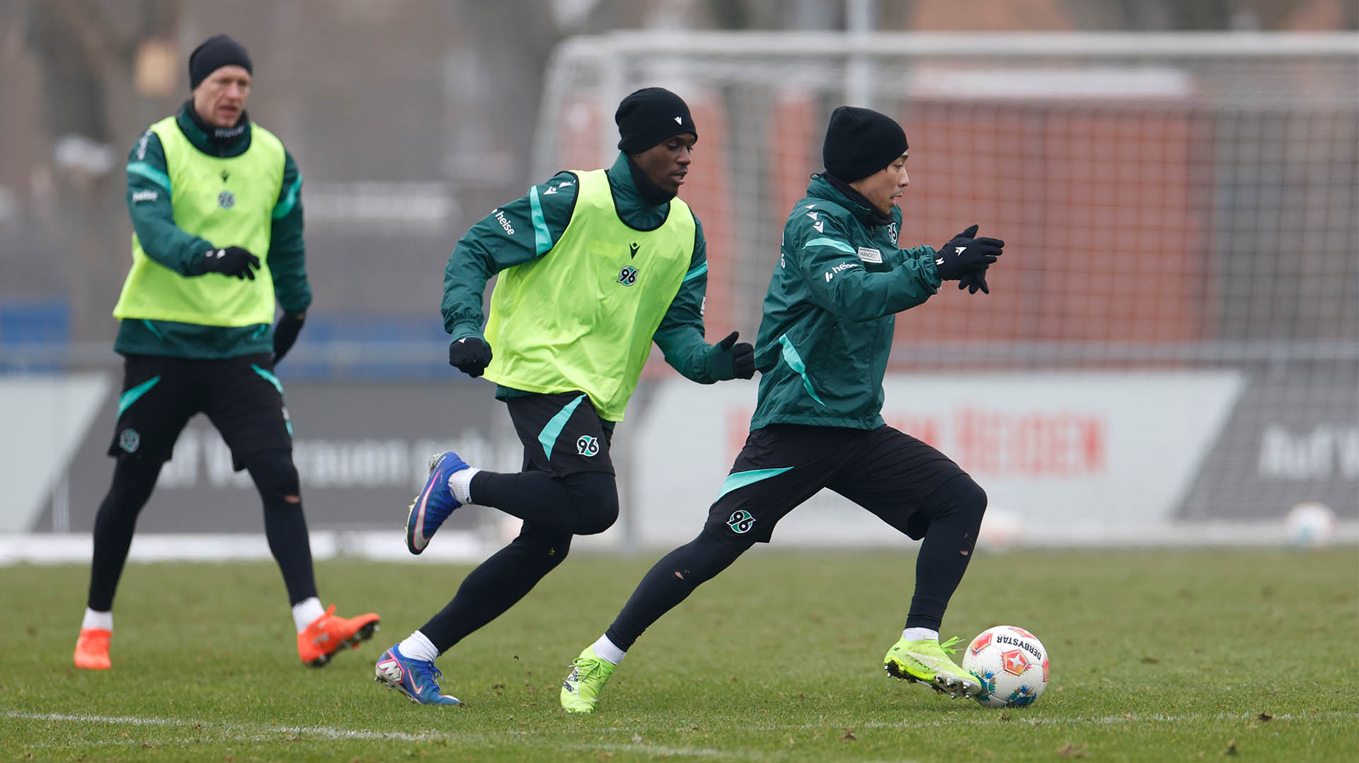 Daisuke Yokota im Laufduell mit William Kokolo am Ball, beide sind dick angezogen.