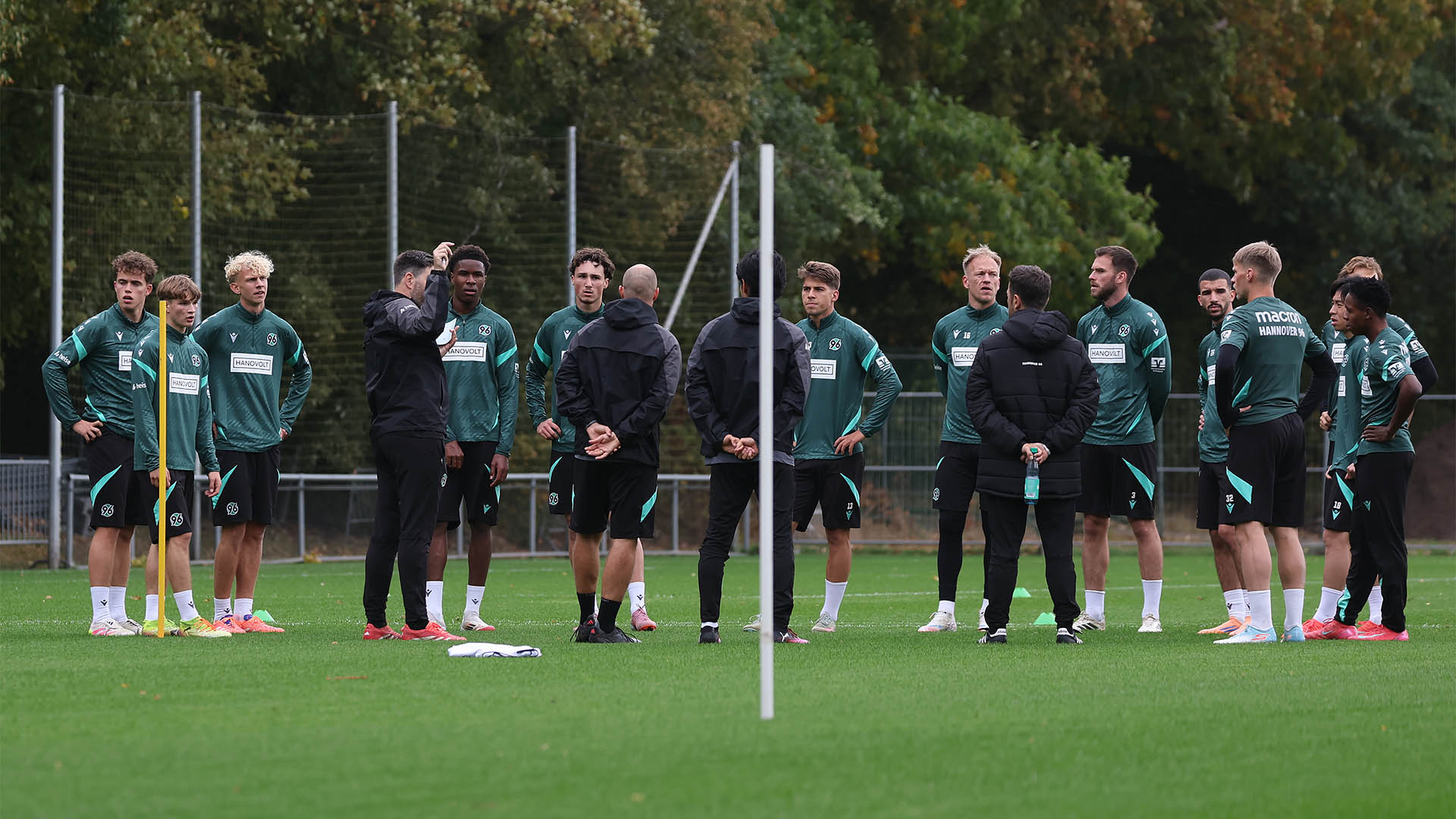 Die Mannschaft steht im Kreis auf dem Trainingsplatz, während André Kilian etwas erklärt.