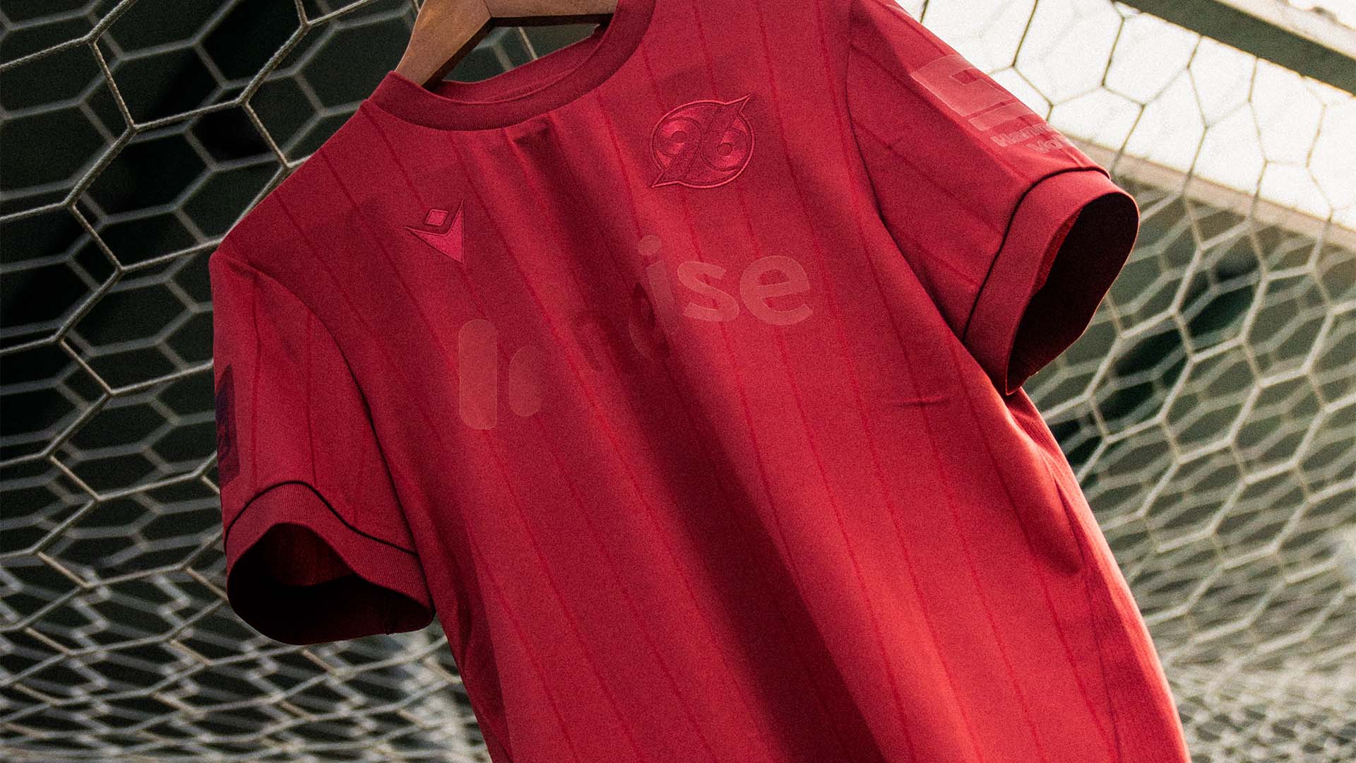 Das 96-Sondertrikot hängt an einem Zaun.