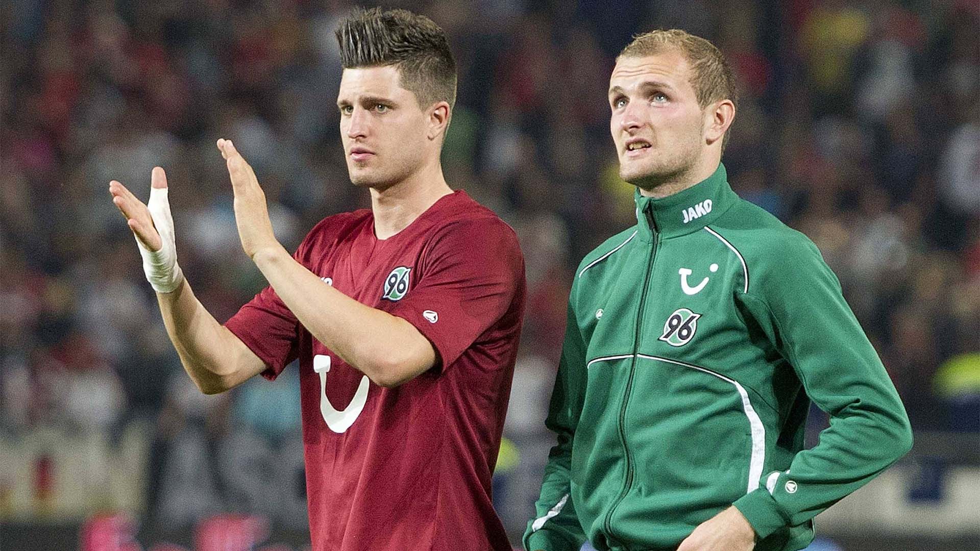 Zwei 96-Spieler drehen eine Runde auf dem Platz, einer klatscht in die Hände.