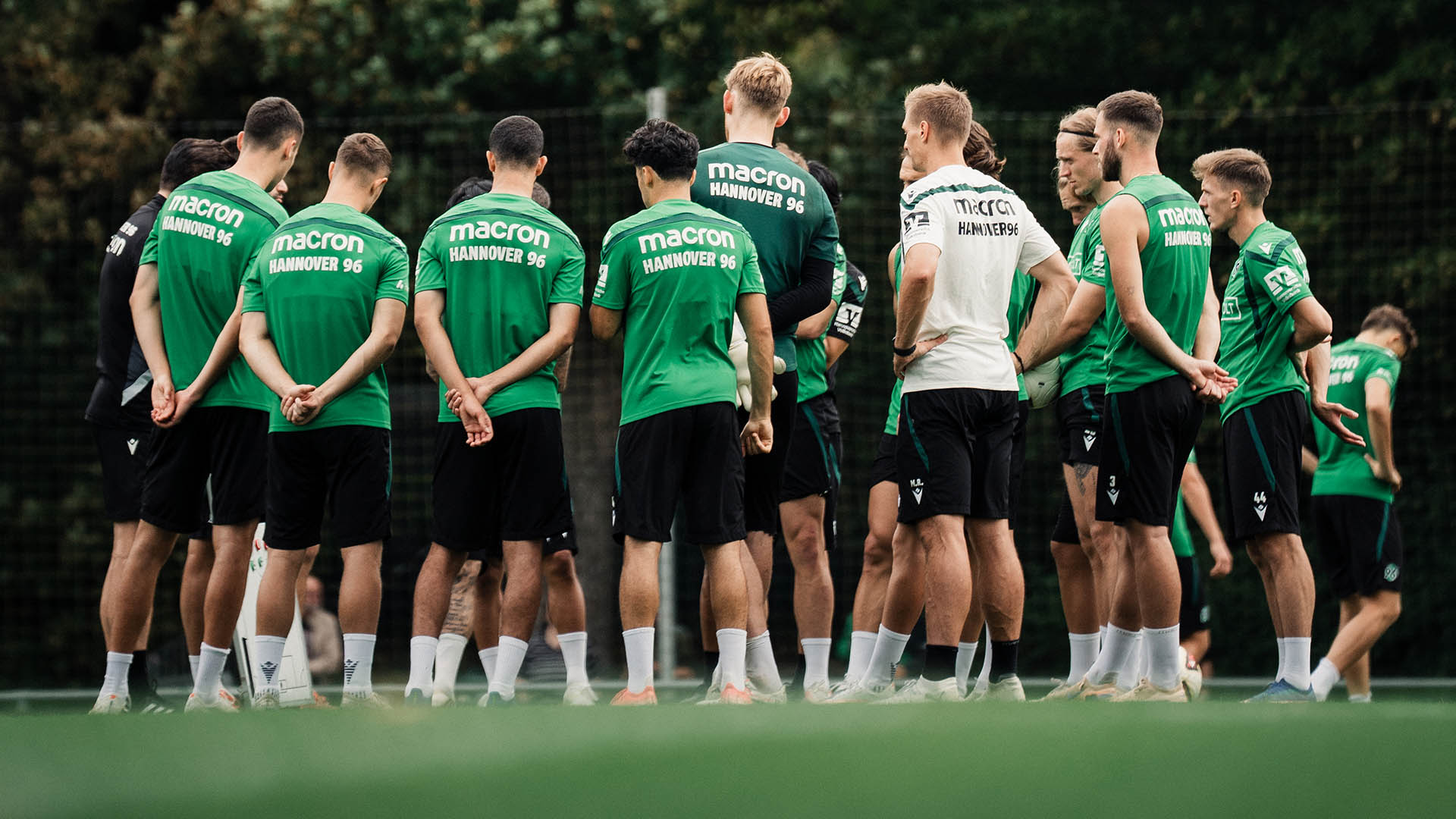 Ein Teil der 96-Mannschaft steht in einem Kreis auf dem Trainingsplatz.