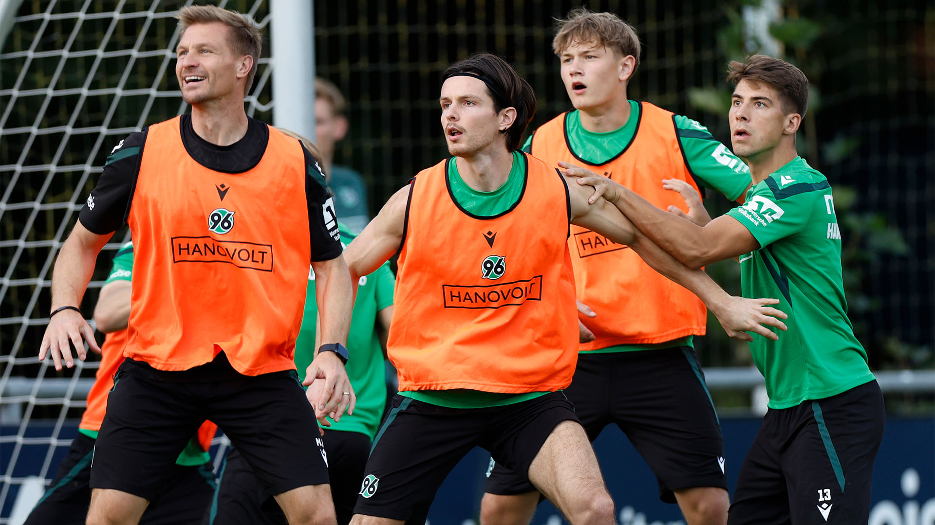 Vier Spieler lauern im Training vor dem Tor auf einen Ball. 