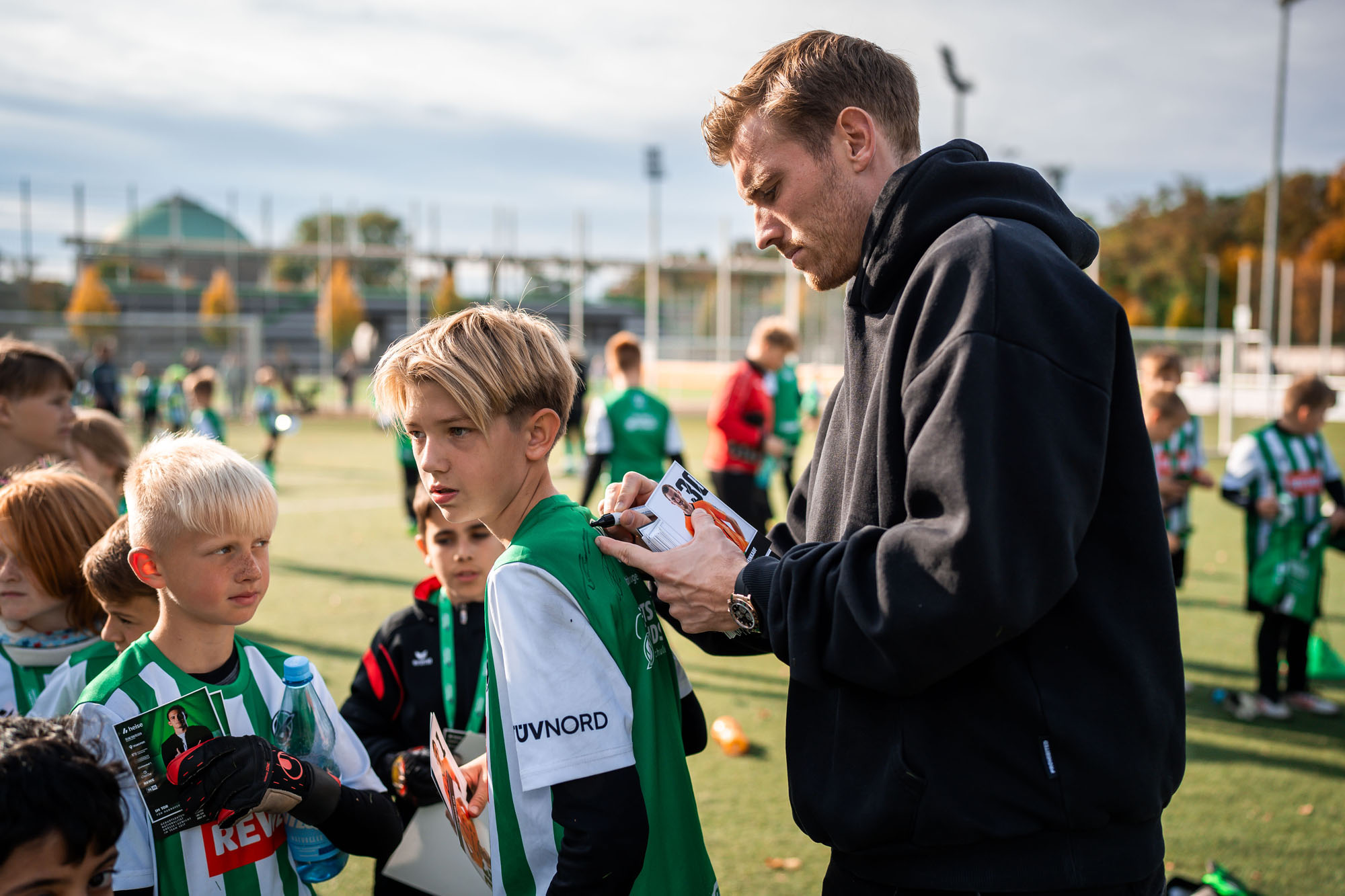 Leo Weinkauf unterschreibt auf dem Trikot eines Jungen.