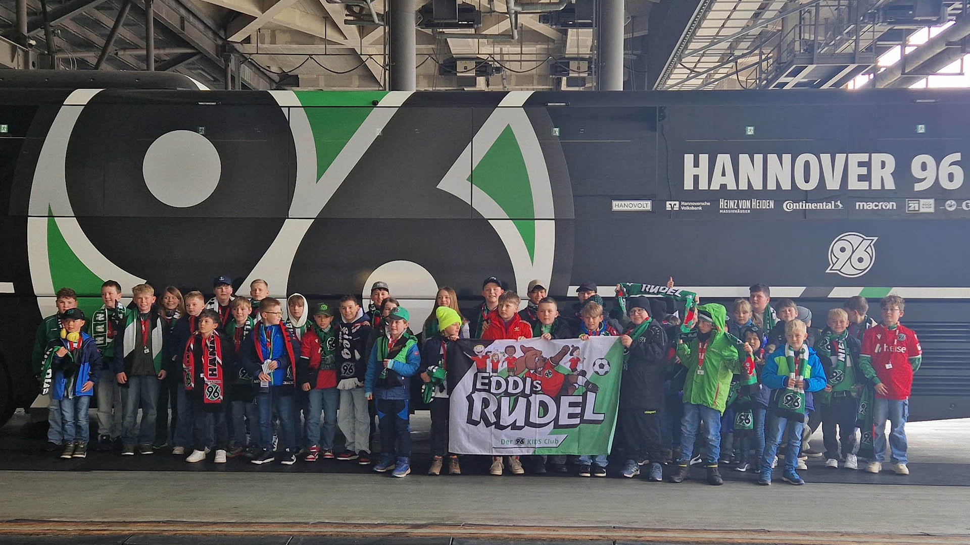 EDDIS Rudel steht für ein Gruppenfoto vor dem schwarzen Mannschaftsbus von Hannover 96.