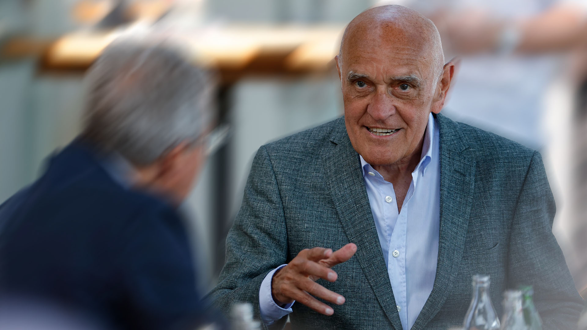 Martin Kind im grauen Sakko und Hemd gestikuliert.