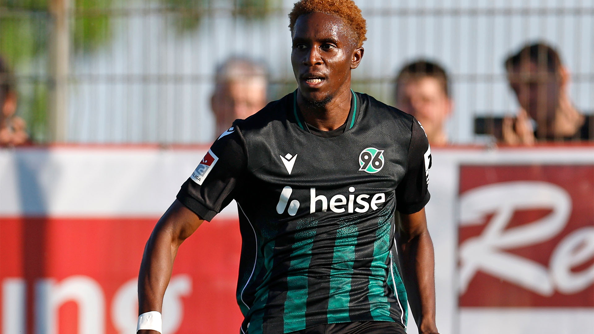 Der 96-Spieler William Kokolo im schwarz-grünen Auswärtstrikot am Ball.