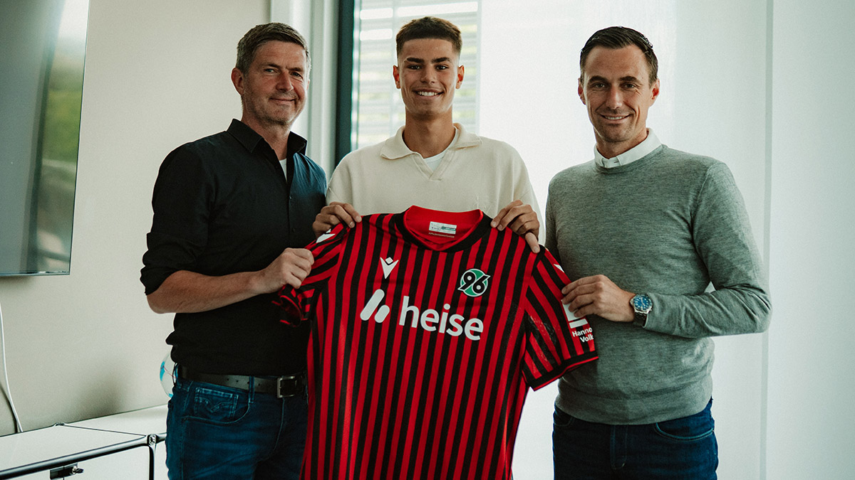 Taycan Kurt hält zusammen mit Marcus Mann und Ralf Becker das Heimtrikot hoch.