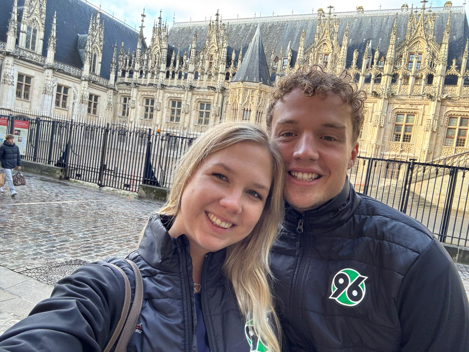 Die Übungleitenden Leonie und Kolja lachen in der Innenstadt von Rouen in die Kamera.