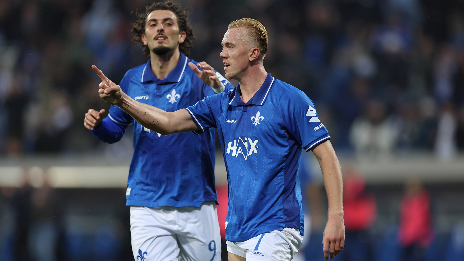 Darmstadt-Stürmer Isac Lidberg mit dem Fingerzeig nach Torerfolg. Im Hintergrund sein Teamkollege Fraser Hornby.