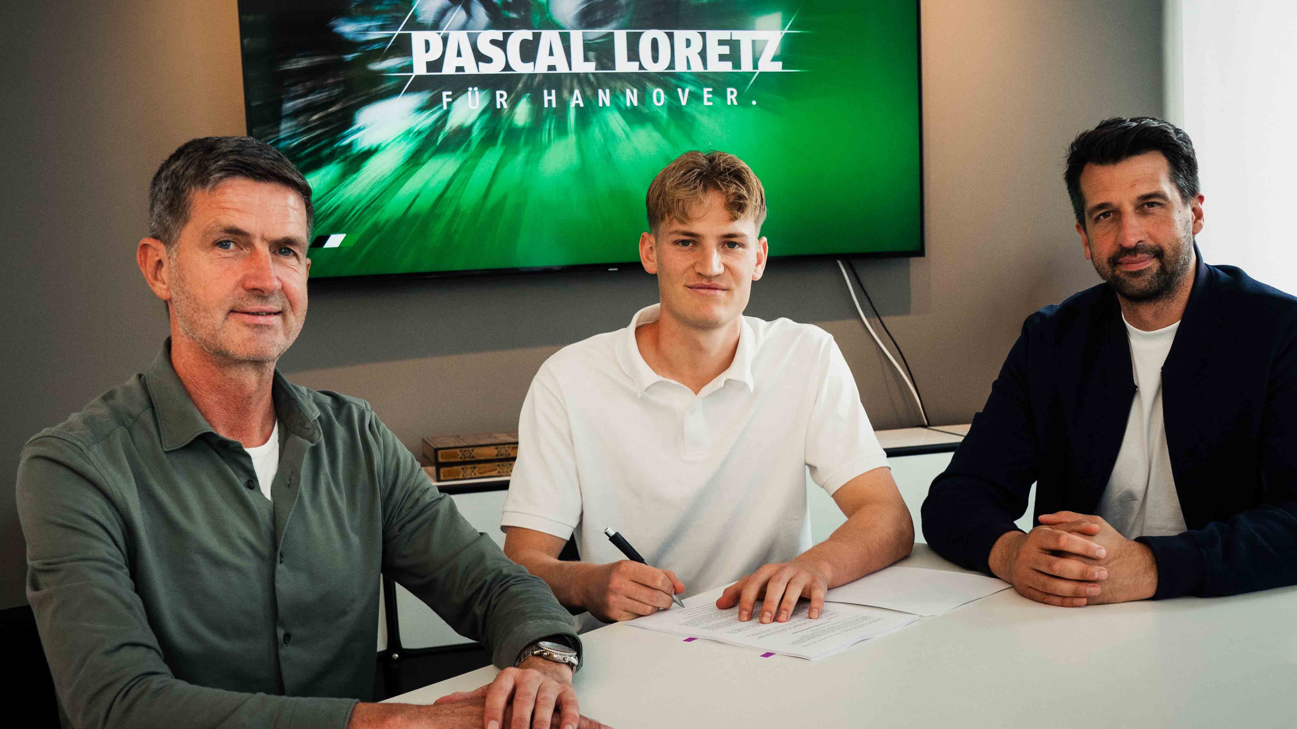 Der neue Spieler mit Ralf Becker und Jonas Boldt im Büro bei der Vertragsunterschrift.
