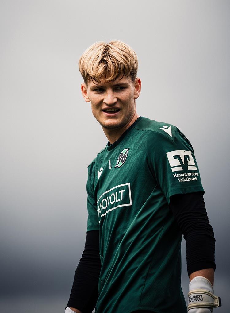 Seitliche Aufnahme von Pascal Loretz in Trainingskleidung, er lächelt leicht.