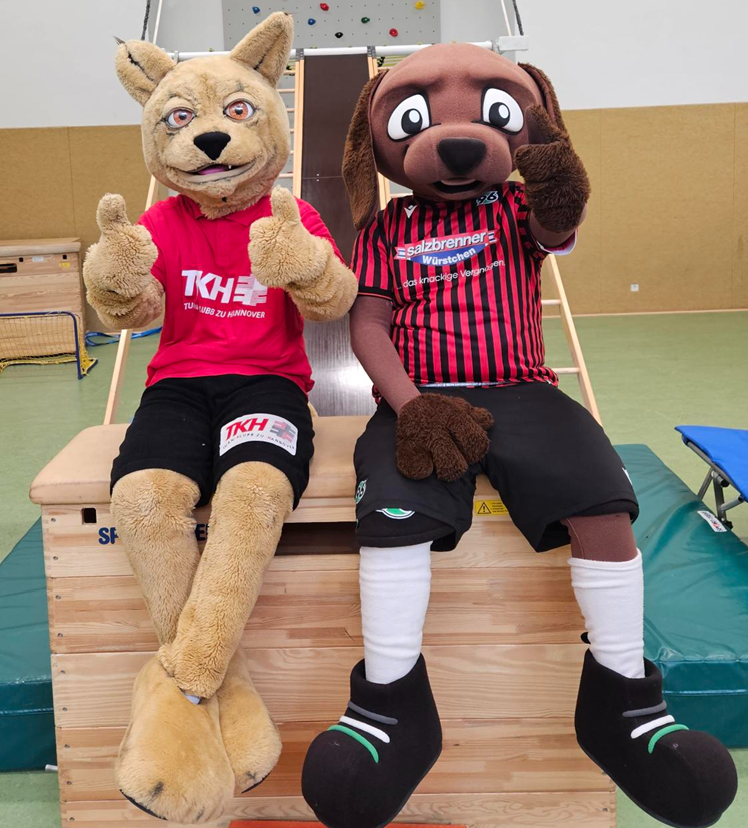 Lucky Luchs und EDDI sitzen auf einer Bank