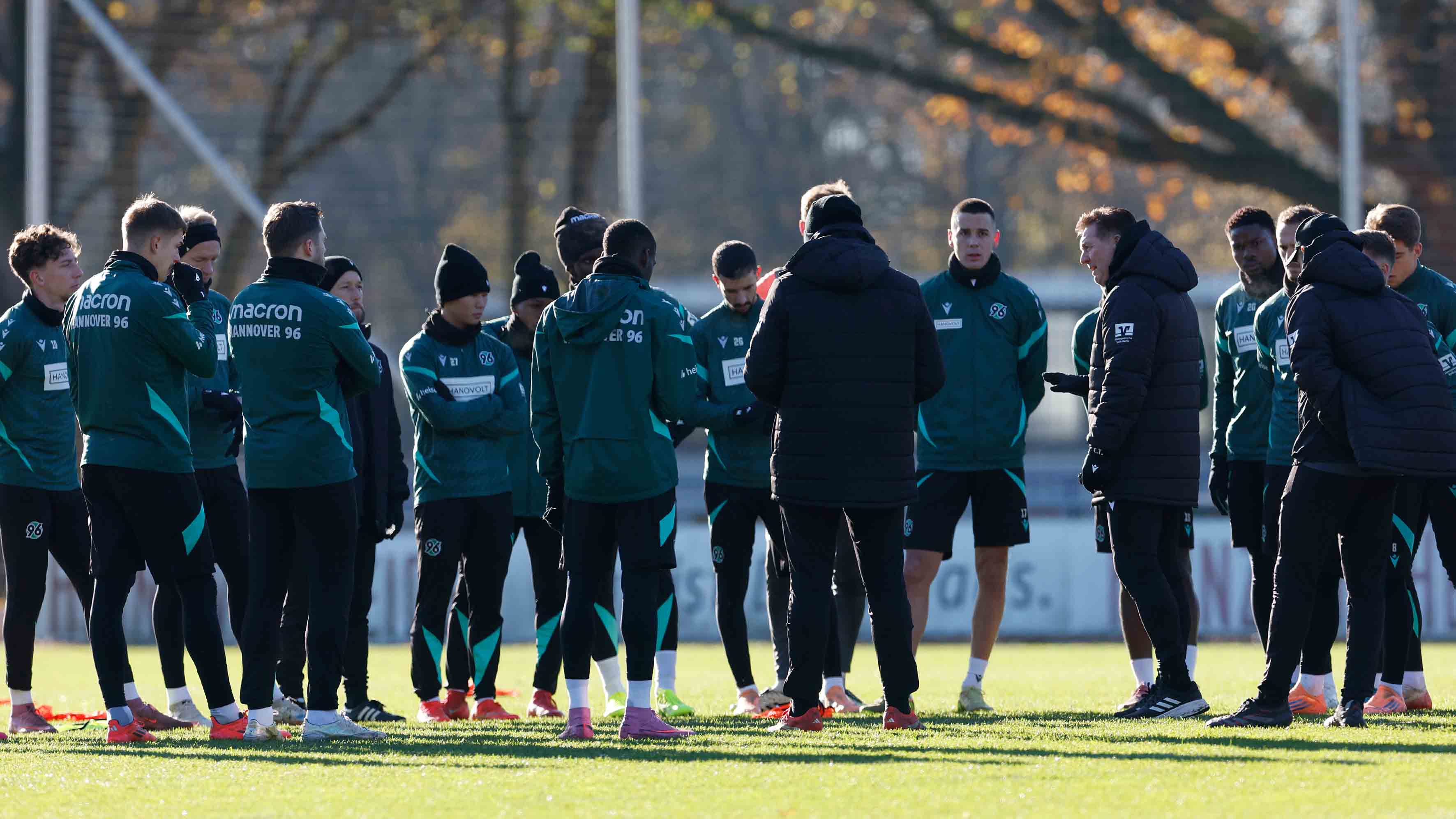 Die 96-Mannschaft steht auf dem Trainingsplatz im Kreis zusammen.
