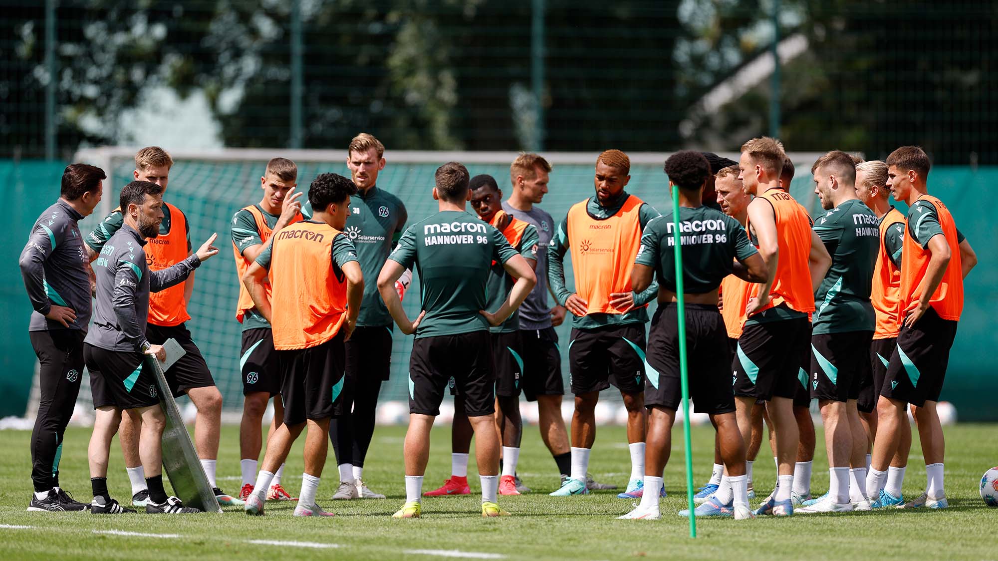 Die 96-Mannschaft steht während des Trainings im Kreis und hört den Trainern zu.