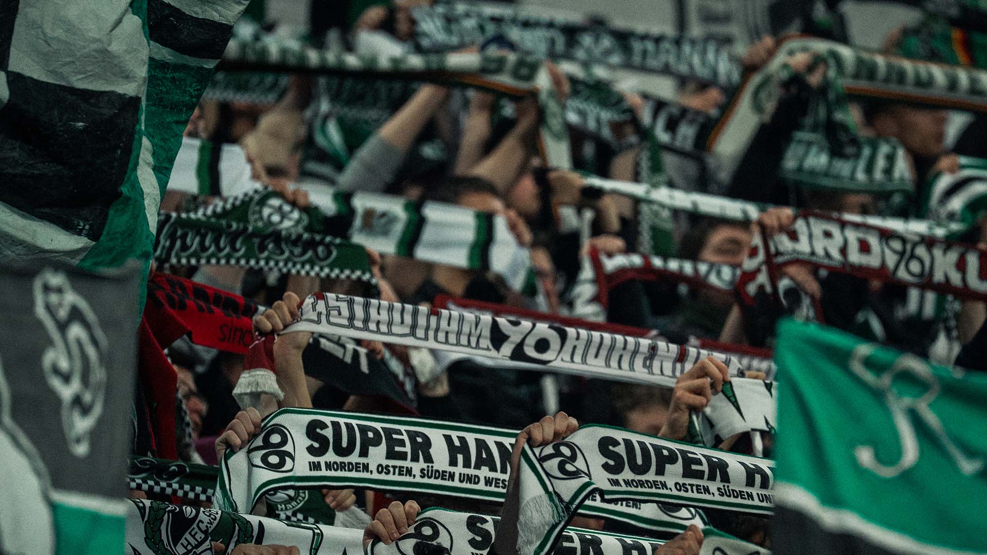 Die Fans halten ihren Schal hoch.