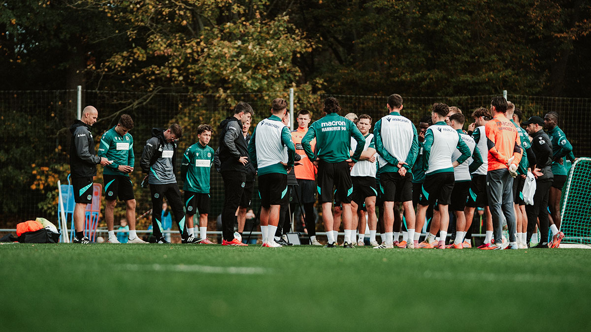 Das 96-Team steht auf dem Trainingsplatz im Kreis zusammen.
