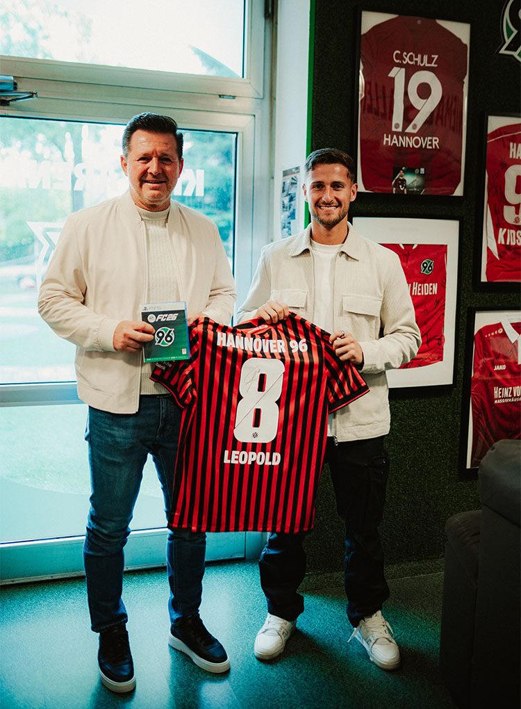 Christian Titz und Enzo Leopold mit einem 96-Trikot und dem aktuellen EAFC-Spiel. 