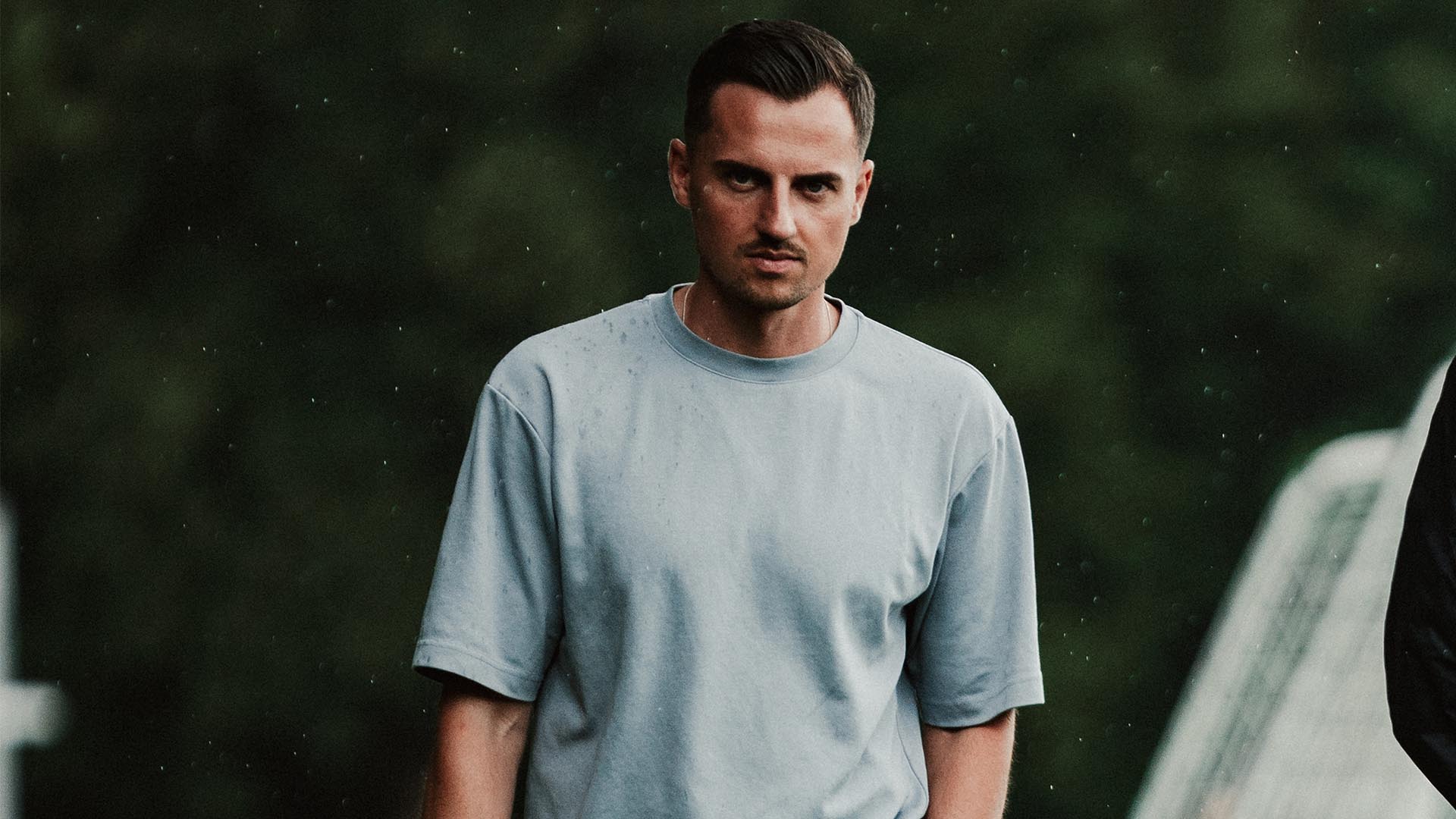 Maximilian Lüftl mit der Hand in einer Hosentasche und dem Handy in der anderen Hand.