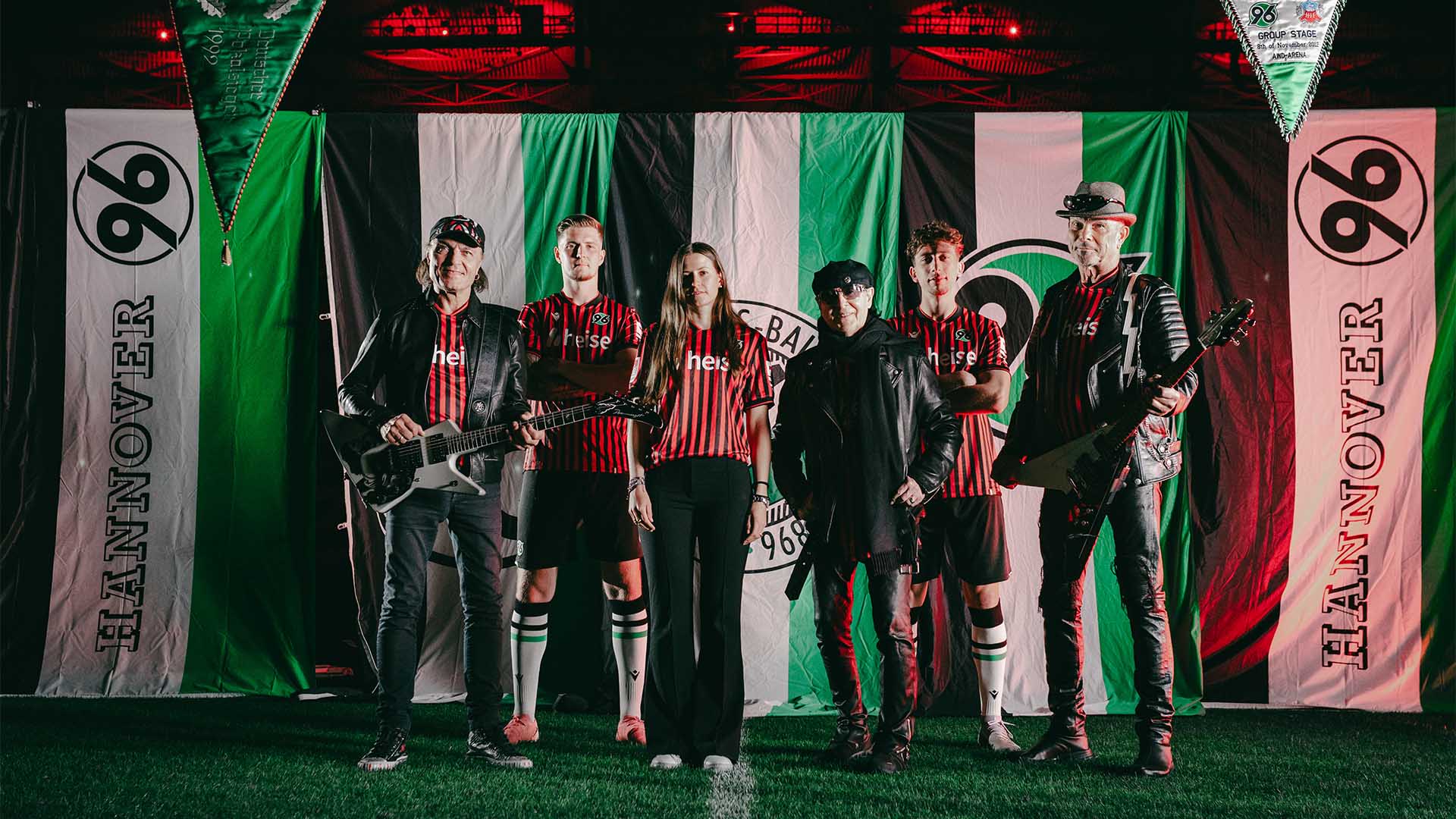 Johanna Heise posiert im 96-Heimtrikot mit Josh Knight und Jannik Rochelt sowie Matthias Jabs, Klaus Meine und Rudolf Schenker von den Scorpions.