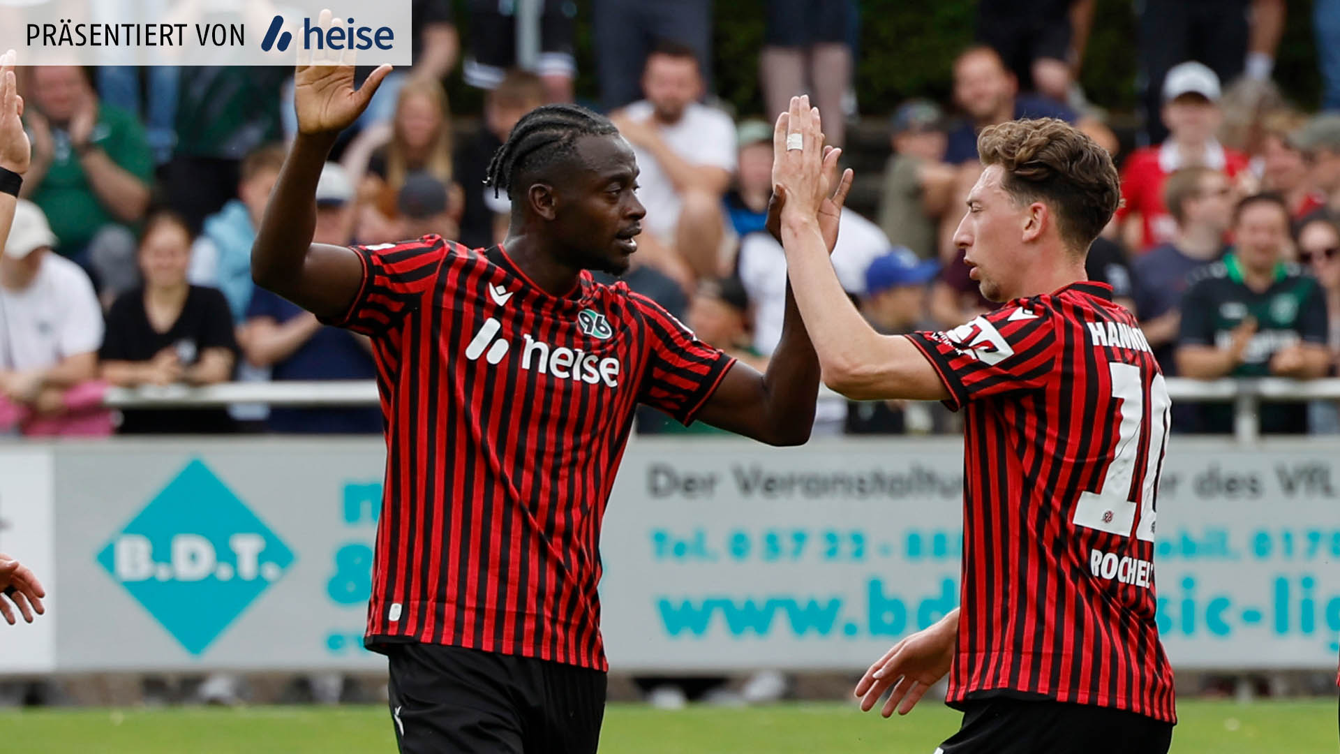 Mustapha Bundu und Jannik Rochelt klatschen mit einer Hand ab.