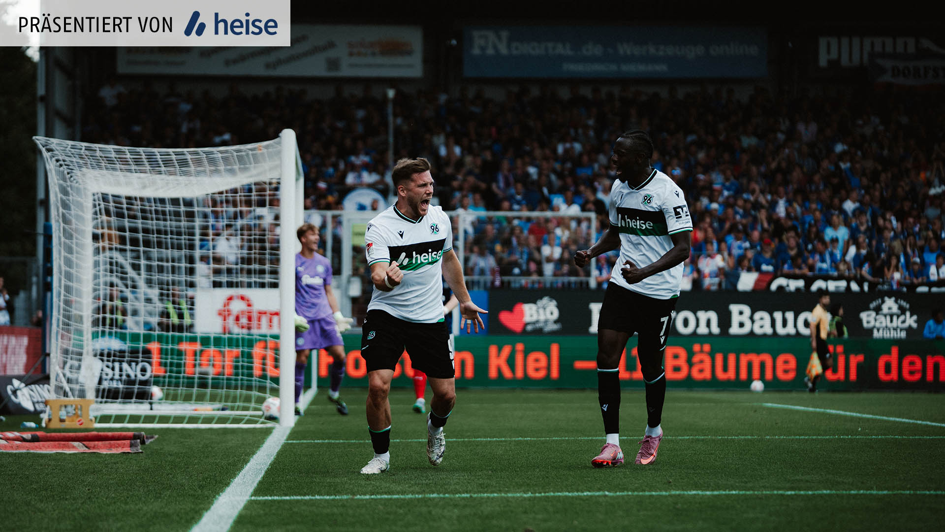 Nach seinem Tor ballt Benjamin Källman im weißen Auswärtstrikot jubelnd die Faust, während Mustapha Bundu als erster gratuliert.