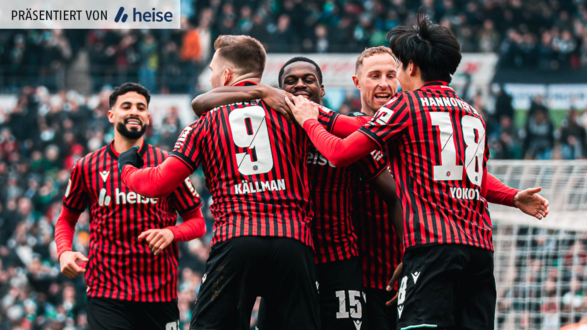 Vier Spieler von Hannover in den rot-schwarz gestreiften Trikots liegen sich in den Armen nach einem Torerfolg. Im Hintergrund kommt ein fünfter Spieler angelaufen. Zwei Spieler sind mit dem Rücken zur Kamera.