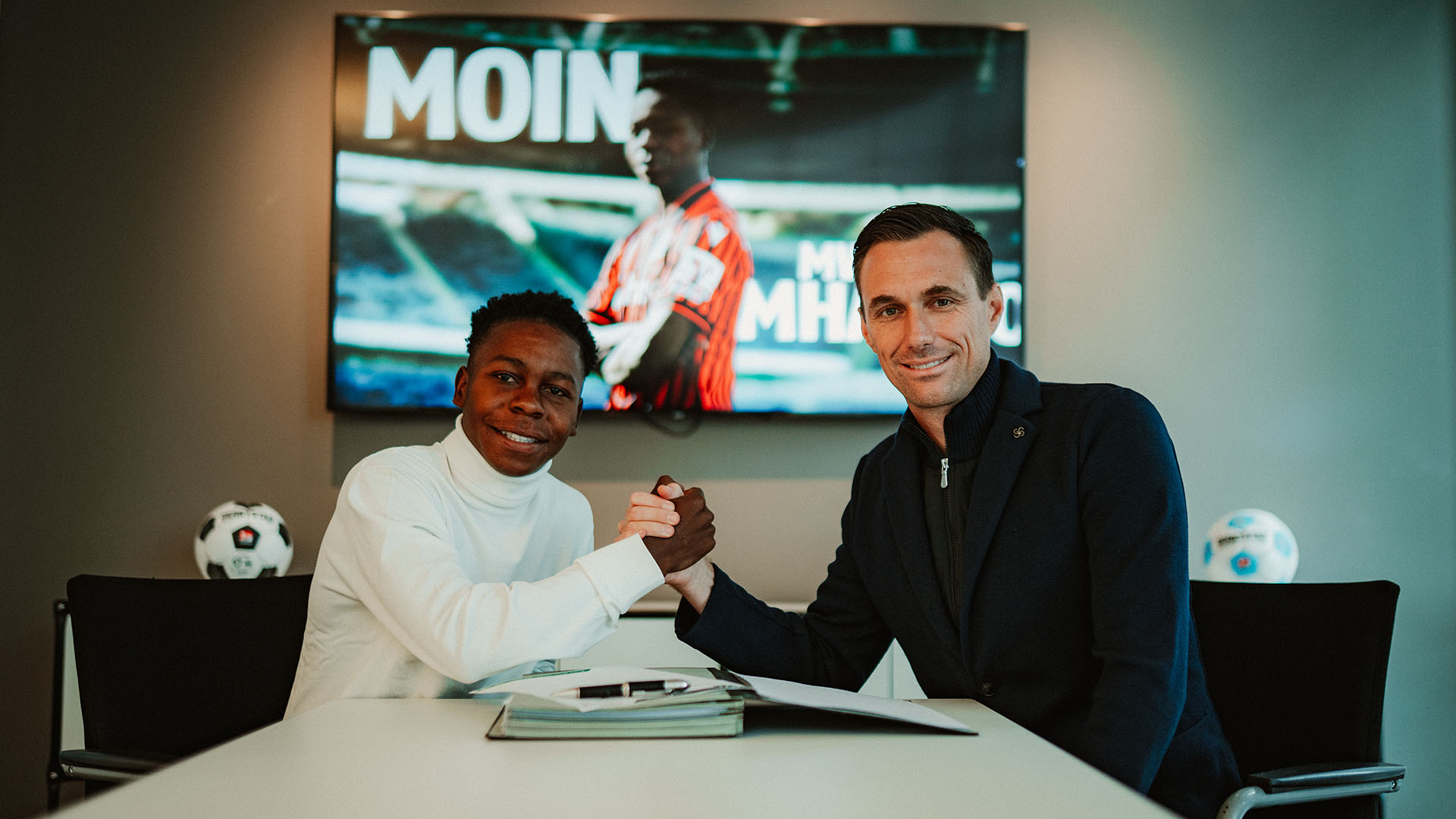 Mwisho Mhango beim Handshake mit 96-Geschäftsführer Marcus Mann in dessen Büro.