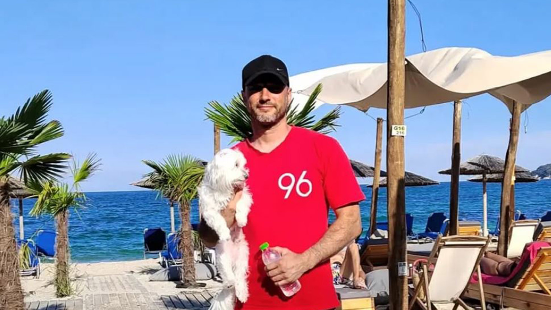 Vladan Milovanovic mit einem Hund auf dem Arm am Strand.